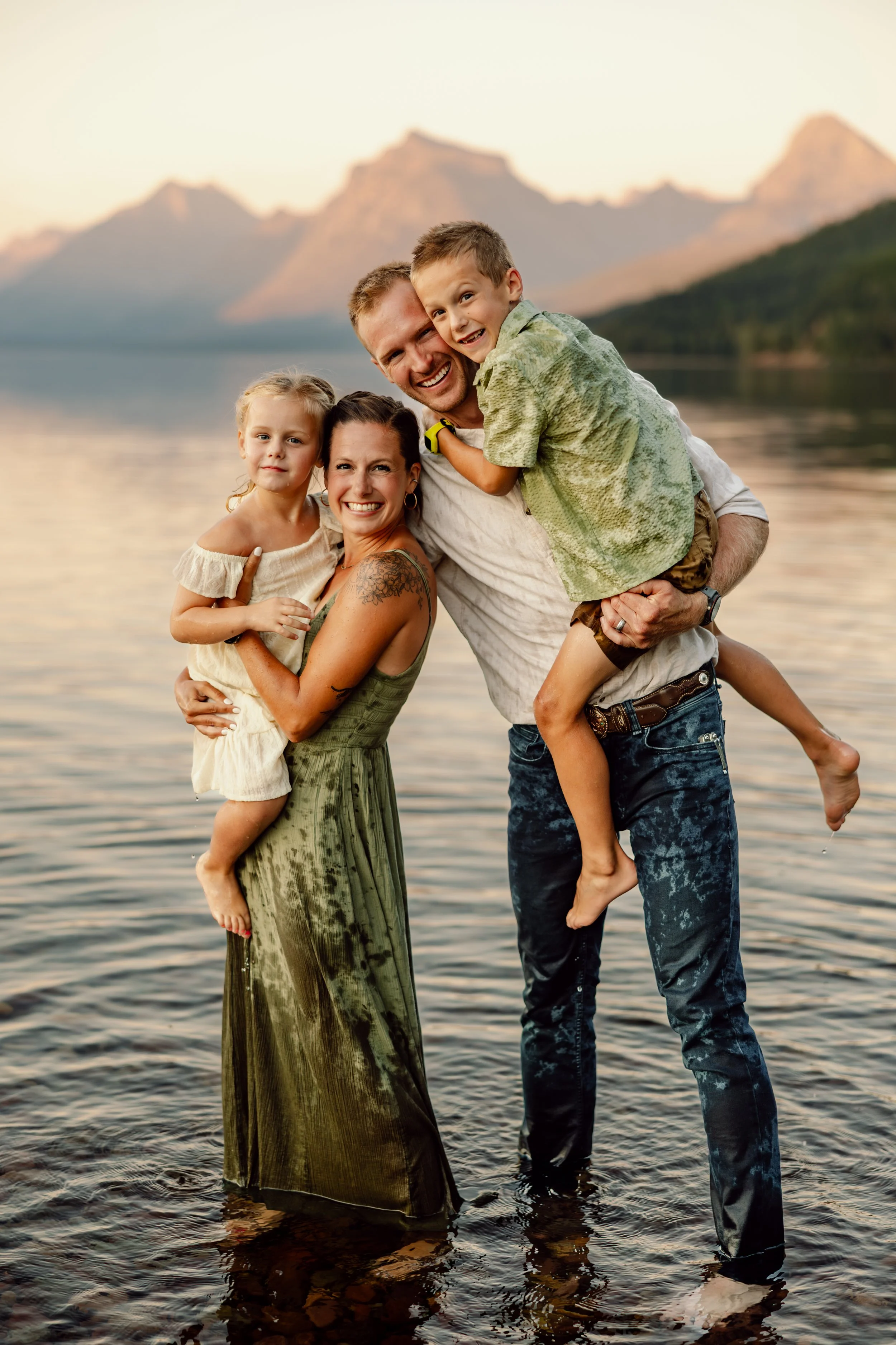 Family of four playing in Lake McDonald during their family photography session in West Glacier, Glacier National Park, Montana