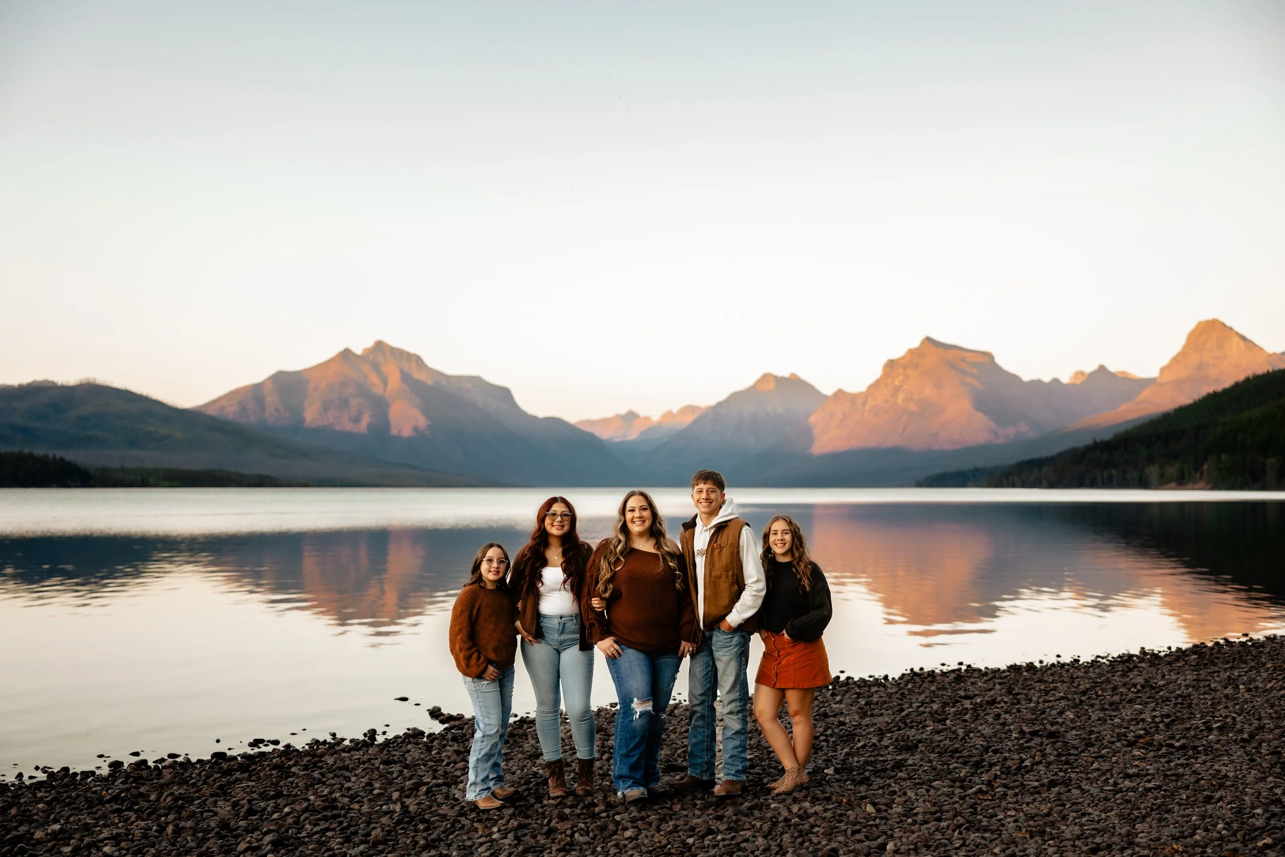 Family of five posing in front of Lake McDonald during their family photography session in West Glacier, Glacier National Park, Montana