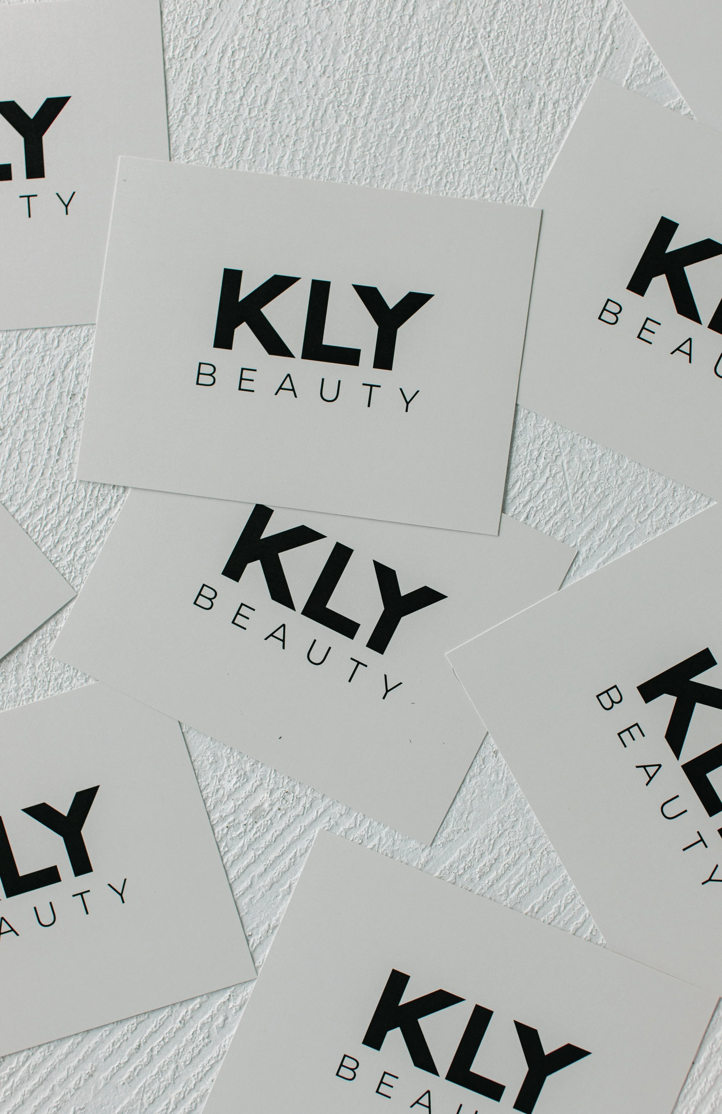 KLY Beauty logo on multiple business cards.
