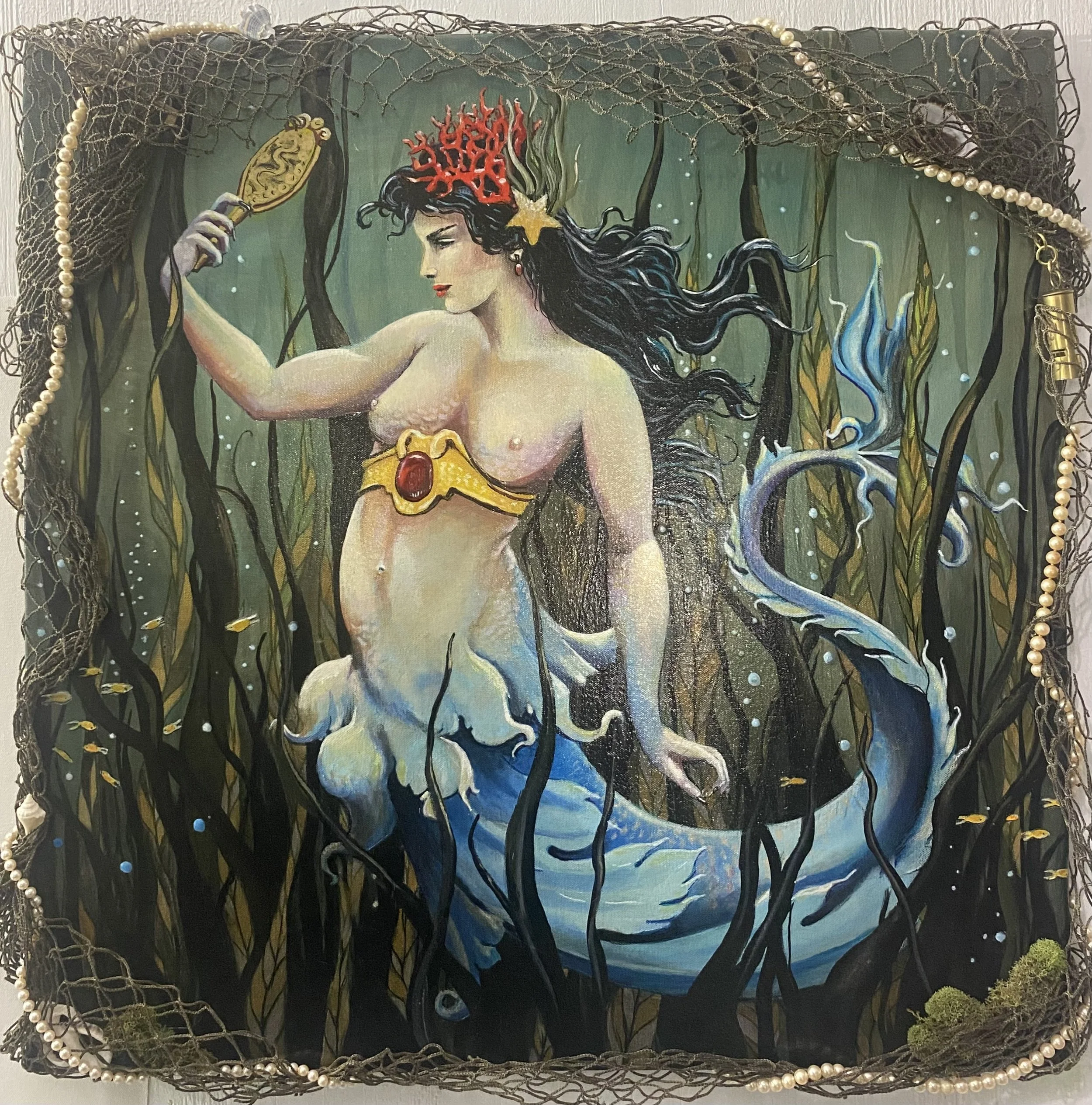 Painting of a mermaid with dark hair, red coral crown, and a yellow jewelry piece, holding a mirror in an underwater setting surrounded by seaweed and small fish, with a decorative border of pearls and netting.