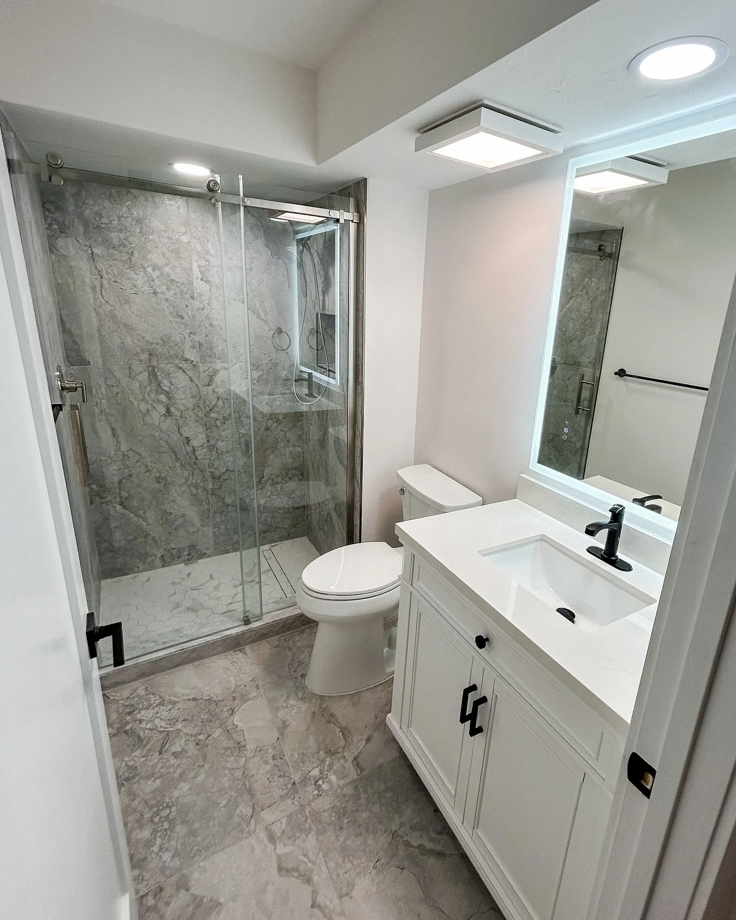 Bright, bold, and refreshed. This bathroom remodel features oversized tile and a backlit LED mirror that adds a touch of modern functionality. 
#BathroomRemodel 
#HomeInspiration
#SWFLRemodeling 
#SouthwestFloridaHomes 
#FloridaLiving 
#HomeRenovatio