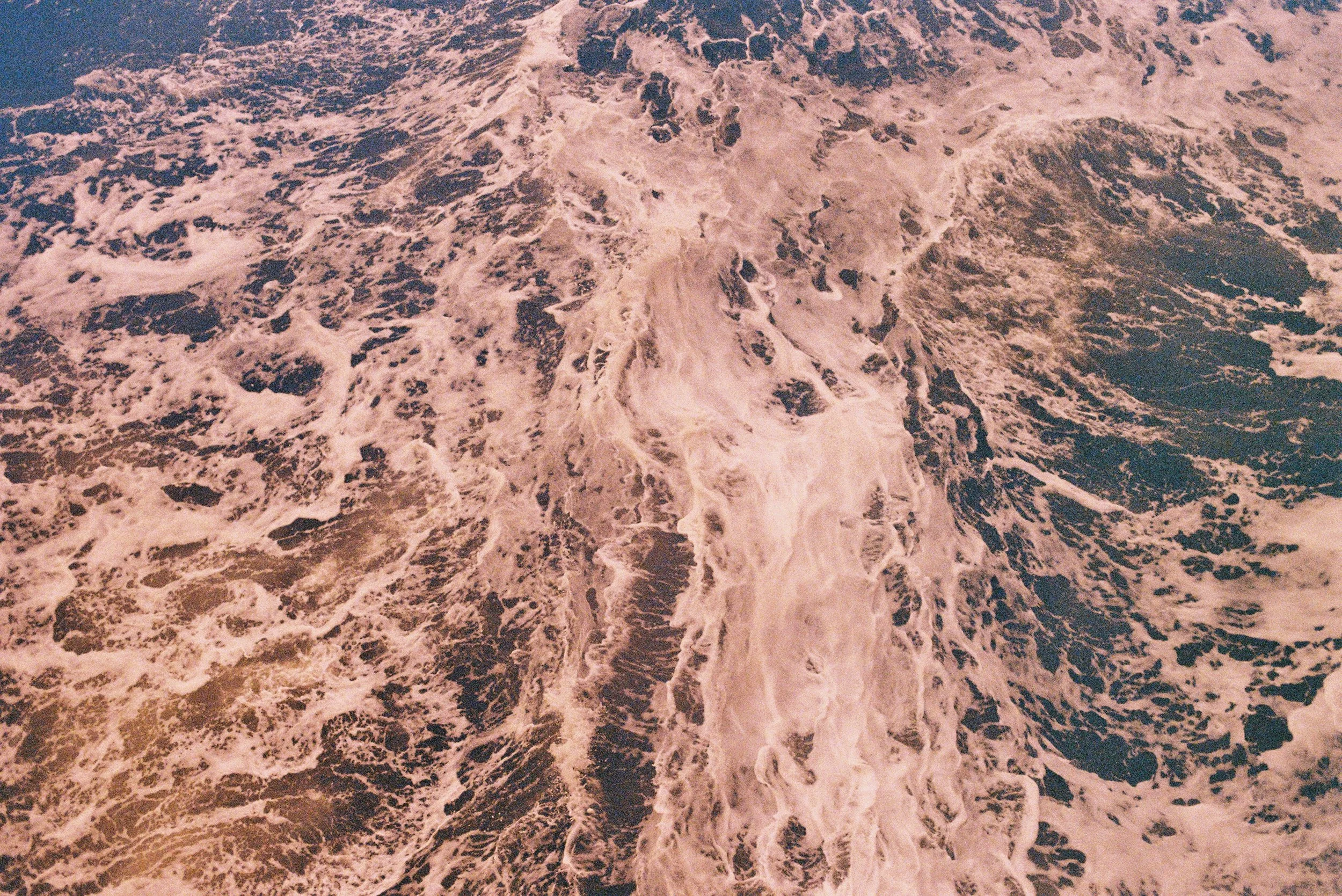 Foamy ocean waves with swirling patterns on the water surface.