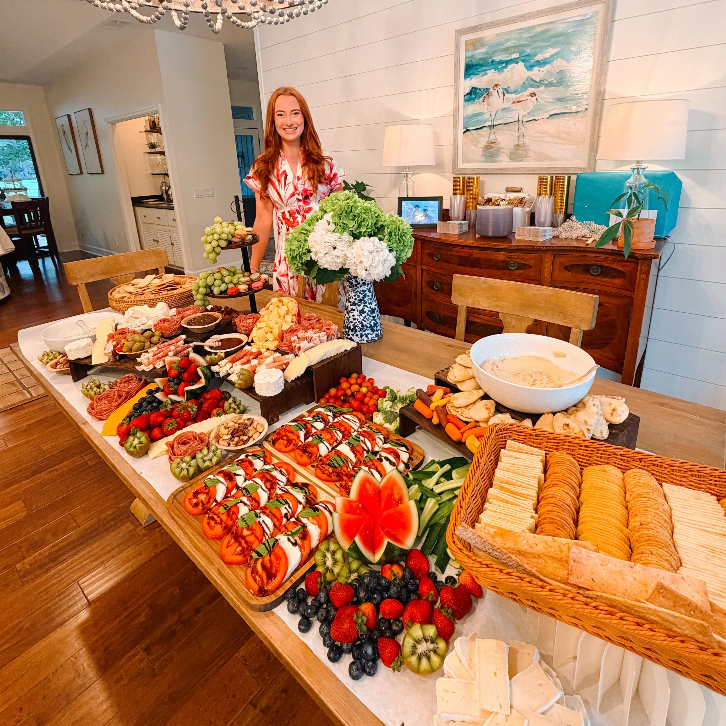 Isabella Shadwick, founder of Boards by Bella, standing behind a charcuterie grazing table.