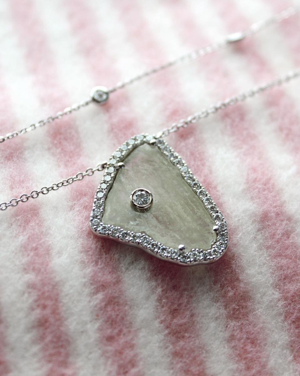 If you&rsquo;re looking for a necklace that is different and makes a statement, you&rsquo;ve found it!

The large stone is a raw cut diamond, with a stationary raw cut diamond half way up the chain. It then features a round brilliant stone halo aroun