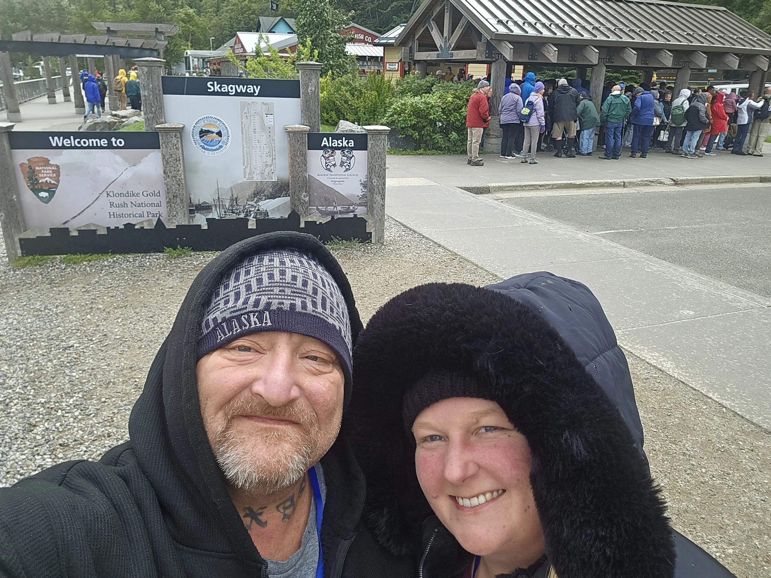K&D Hospitality Services owners taking a selfie in Skagway, Alaska, near the Klondike Gold Rush National Historical Park during their Alaska cruise.
