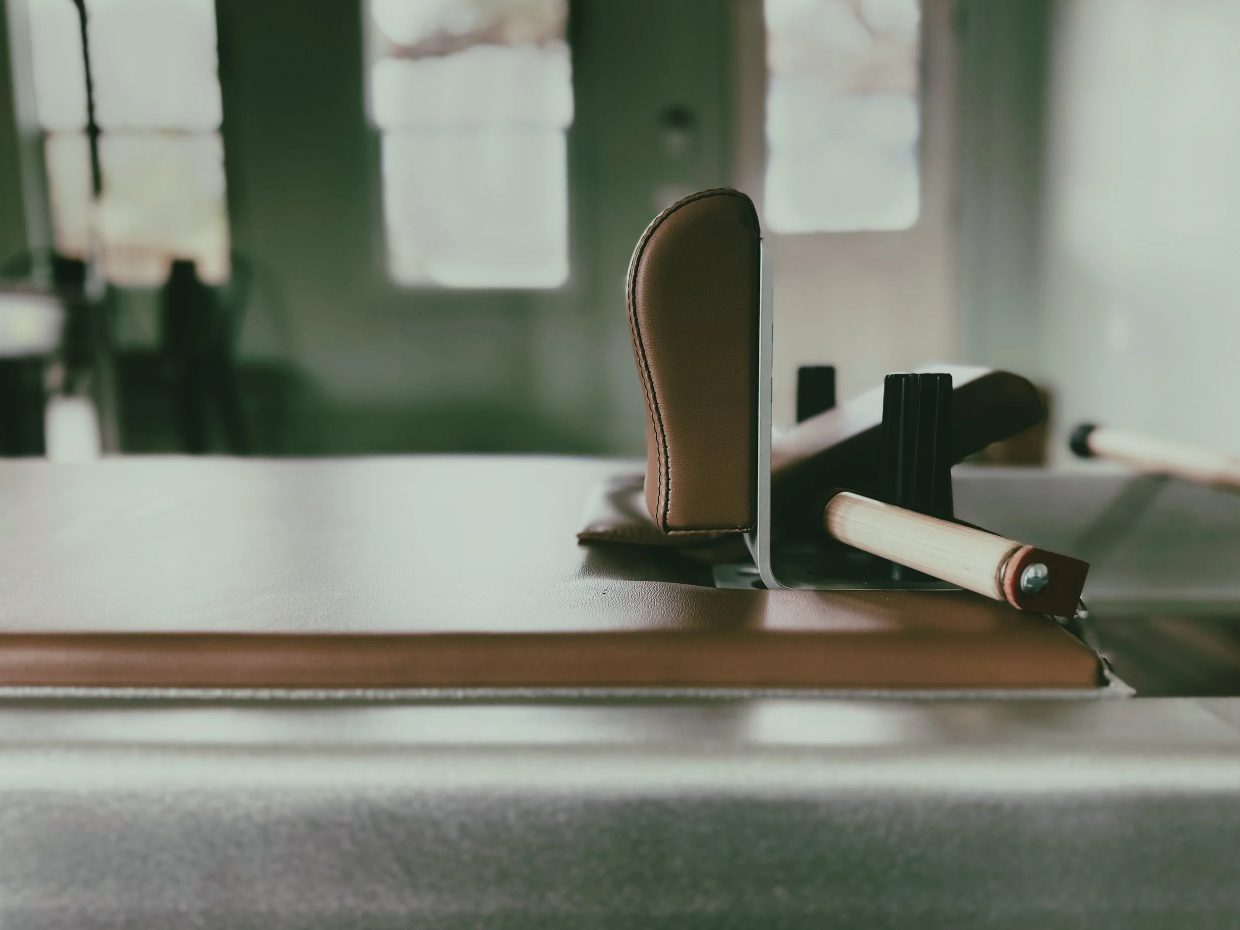 Image of a classical Pilates reformer with controued shoulder blocks, carriage divets, and wooden handles that make all the difference.