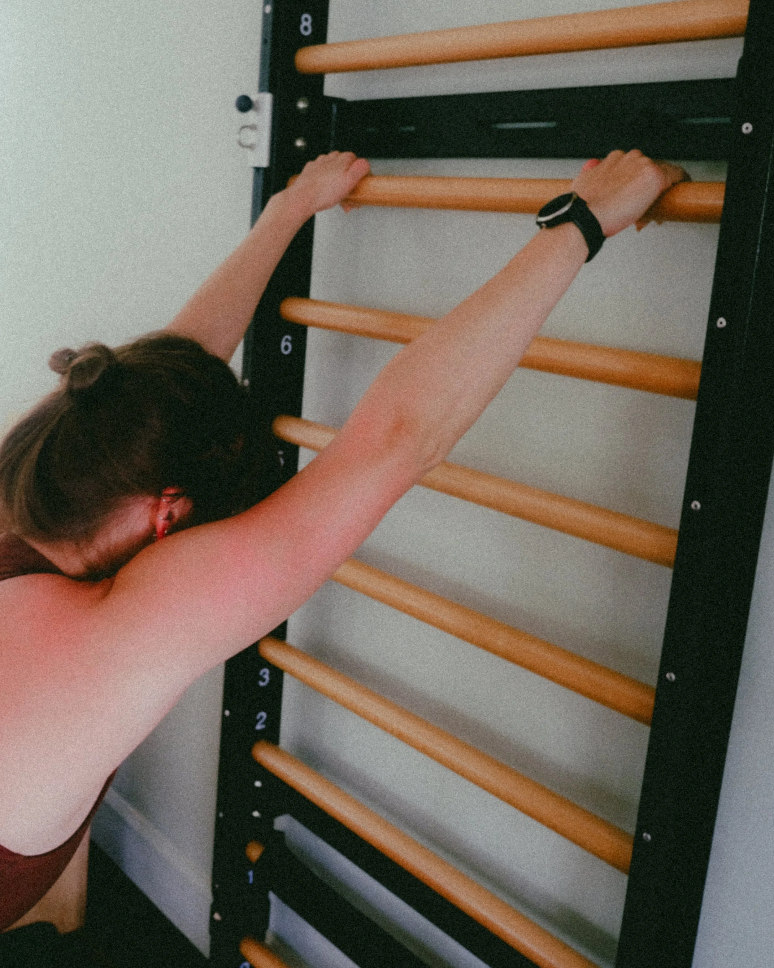 Image of a student stretching on a Fuse Ladder at The Pilates Garage.