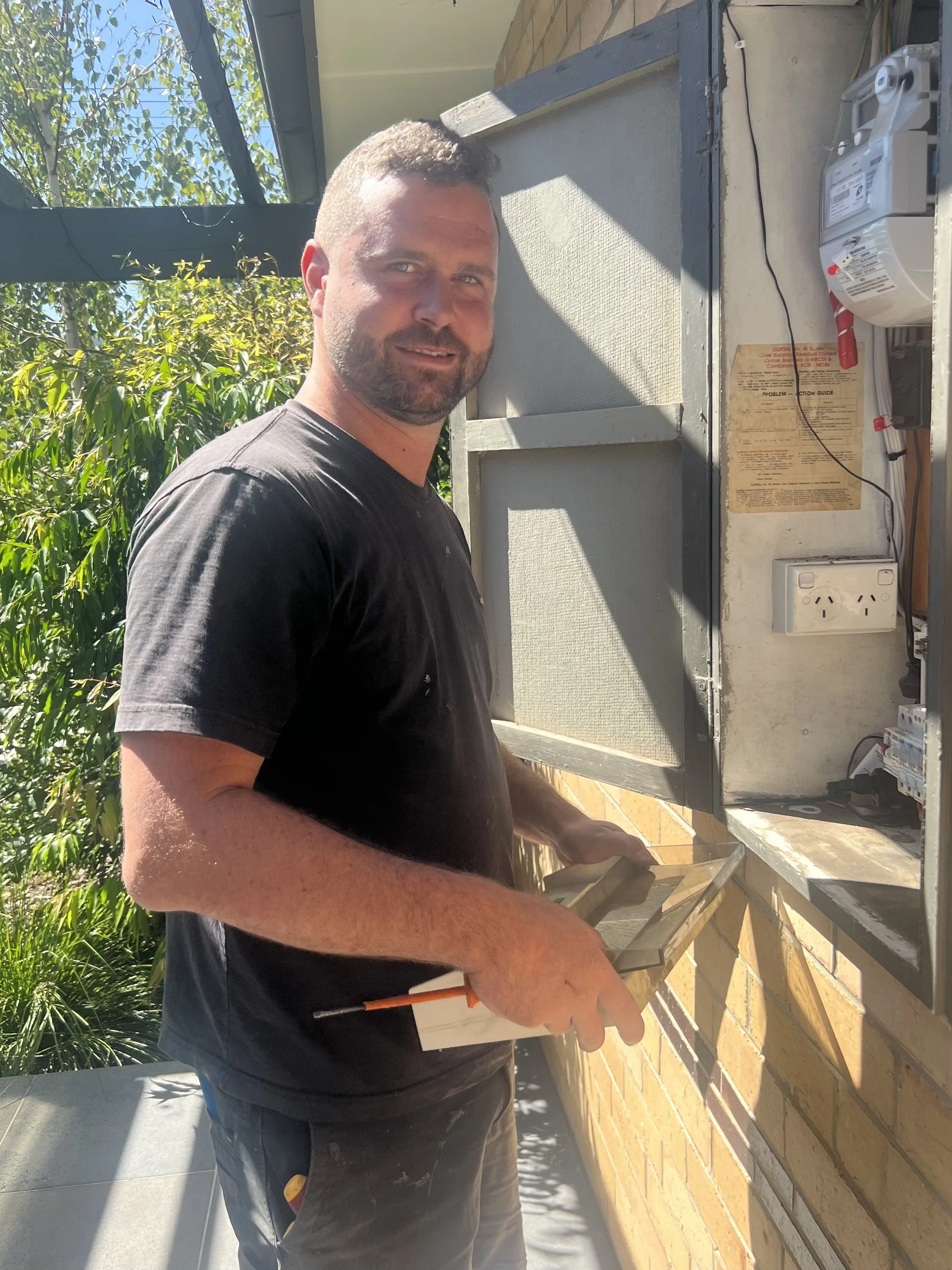A man working outdoors near an electrical panel