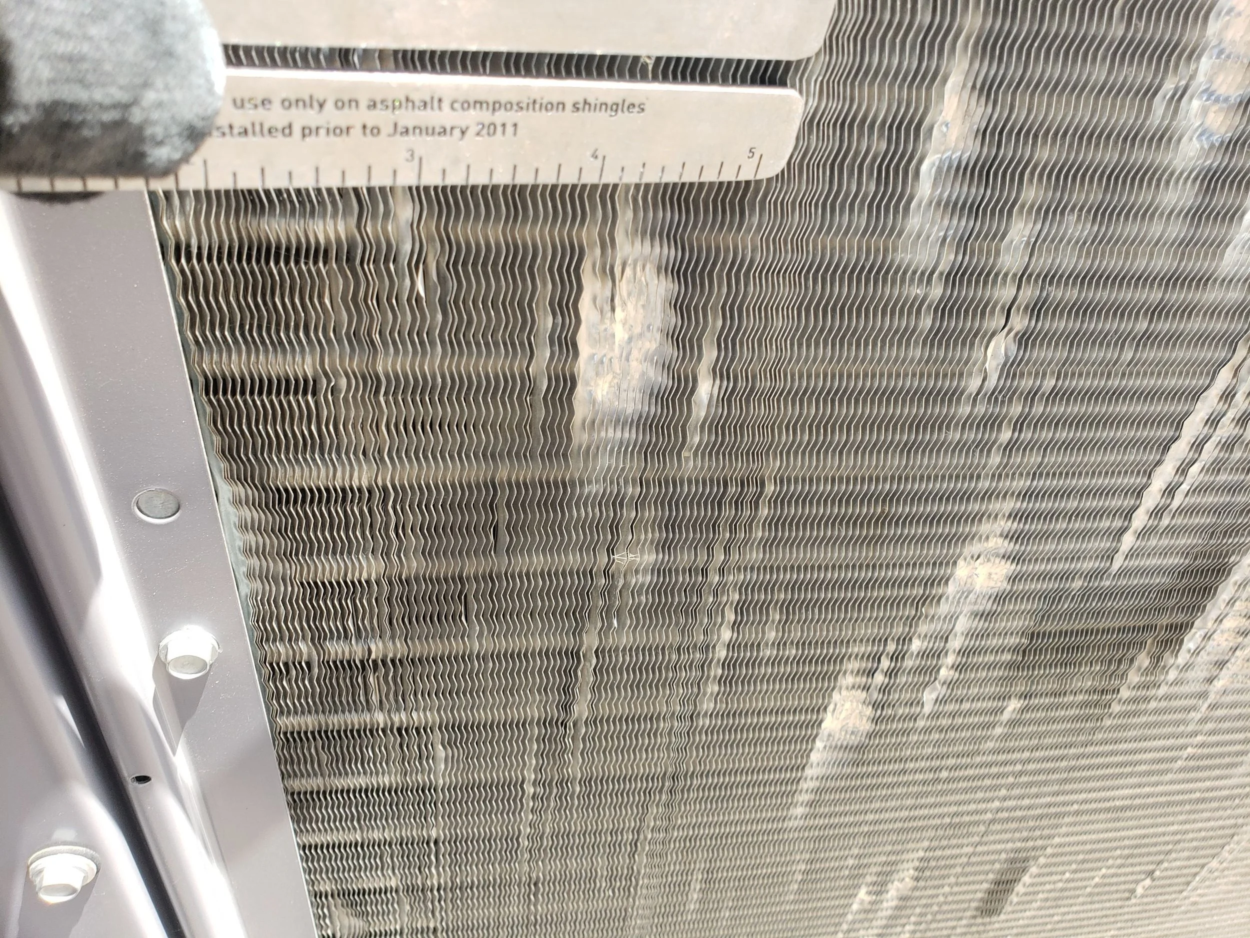 close up photo of hail damage to AC and condenser unit 