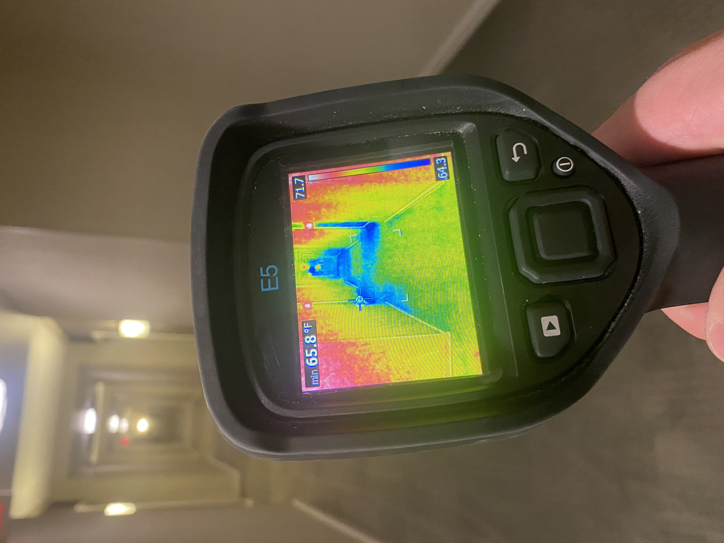 A thermal imaging FLIR camera indicating moisture in a hallway 