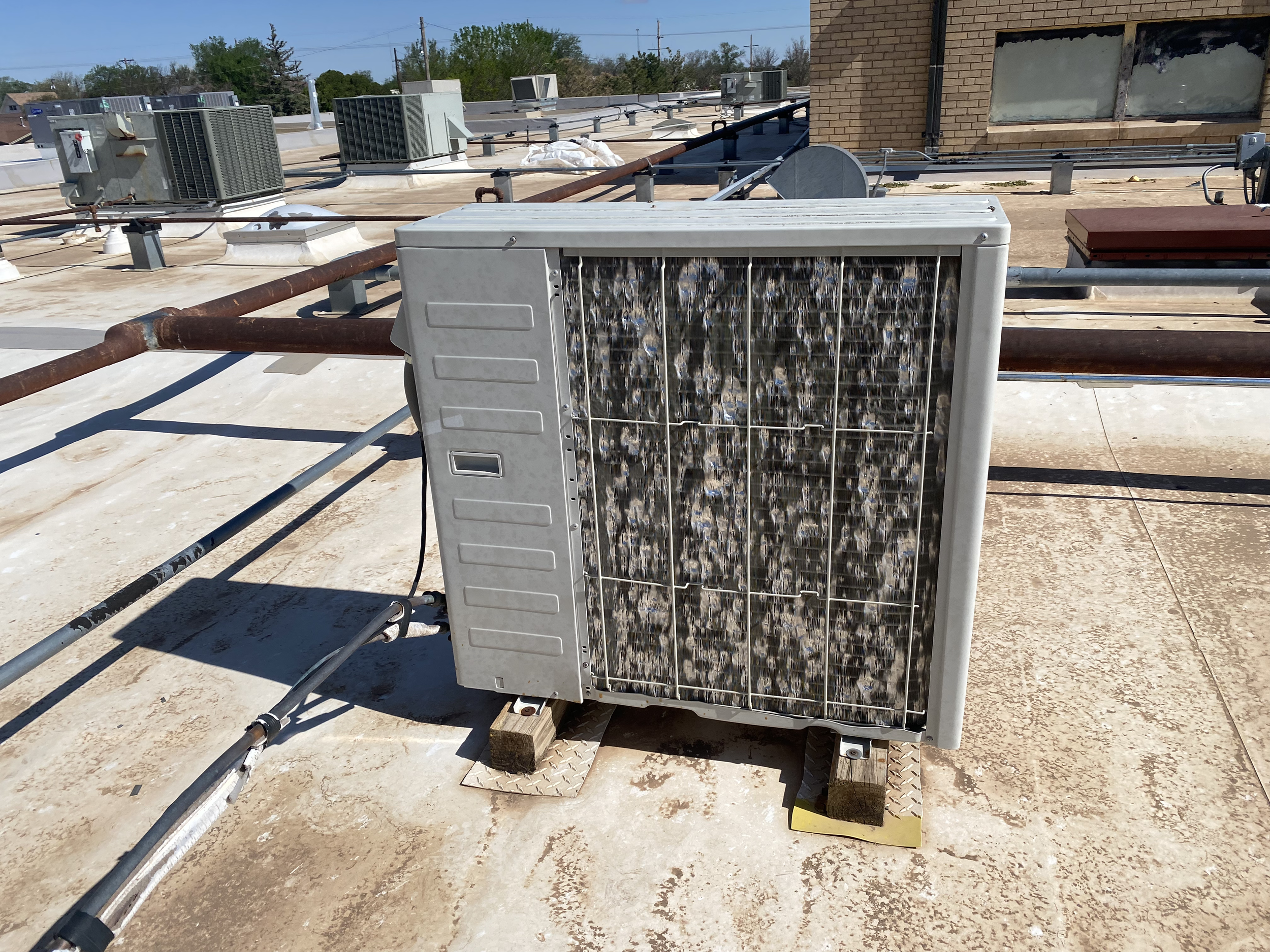 Hail damage to AC unit and condenser on TPO commercial flat roof