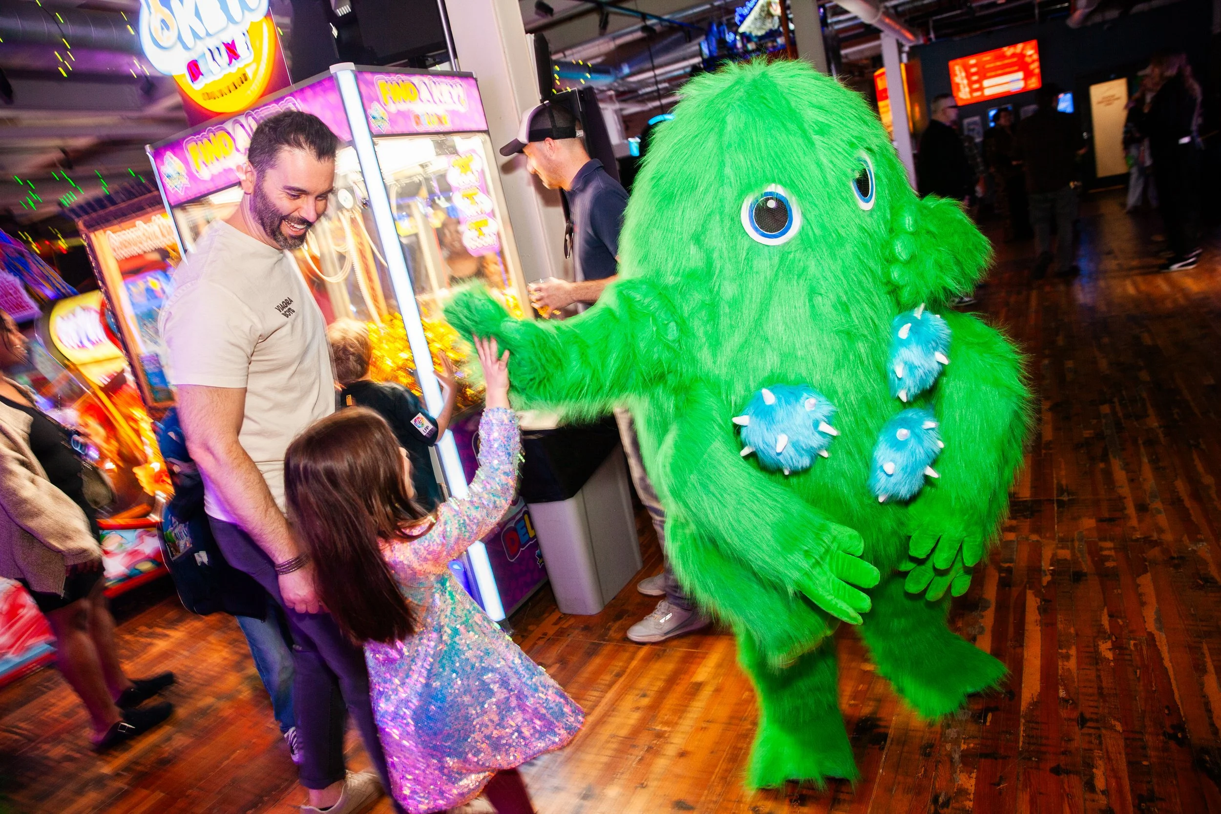 A young girl high-fiving Elston Electric's mascot, The Hooky Monster