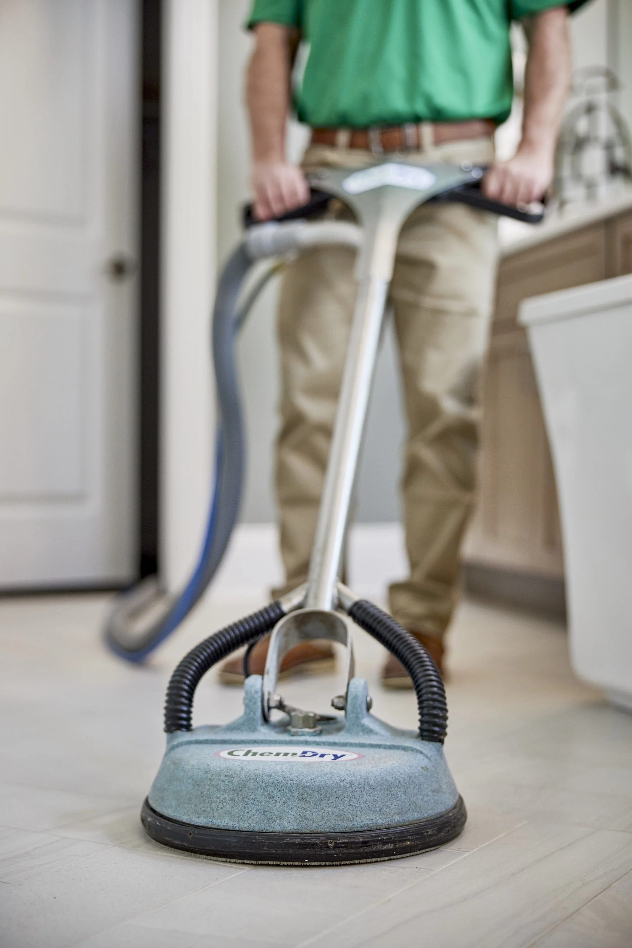 Person using a floor cleaning machine in a home setting.