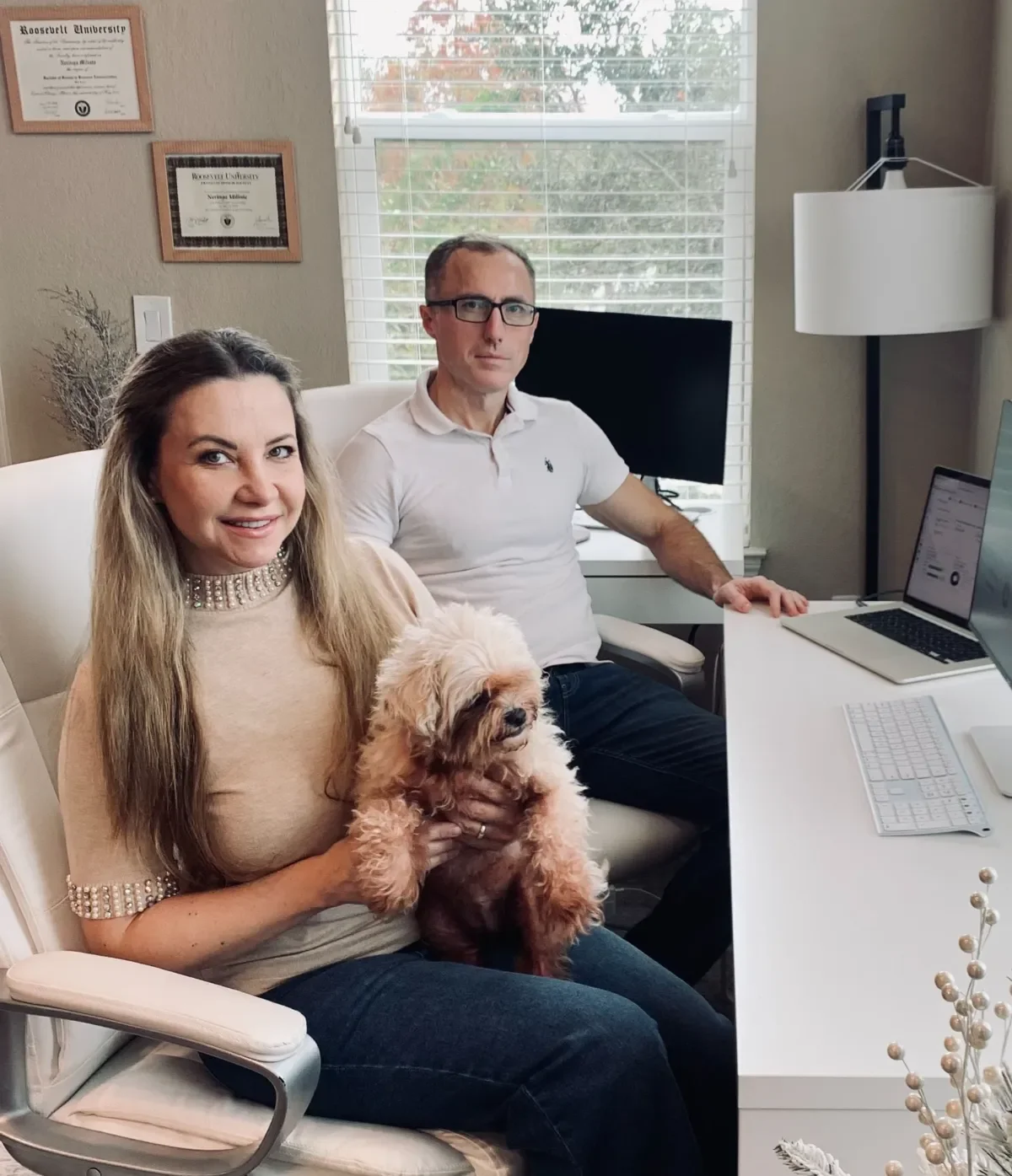 Bookkeepers working at a desk while holding a puppy