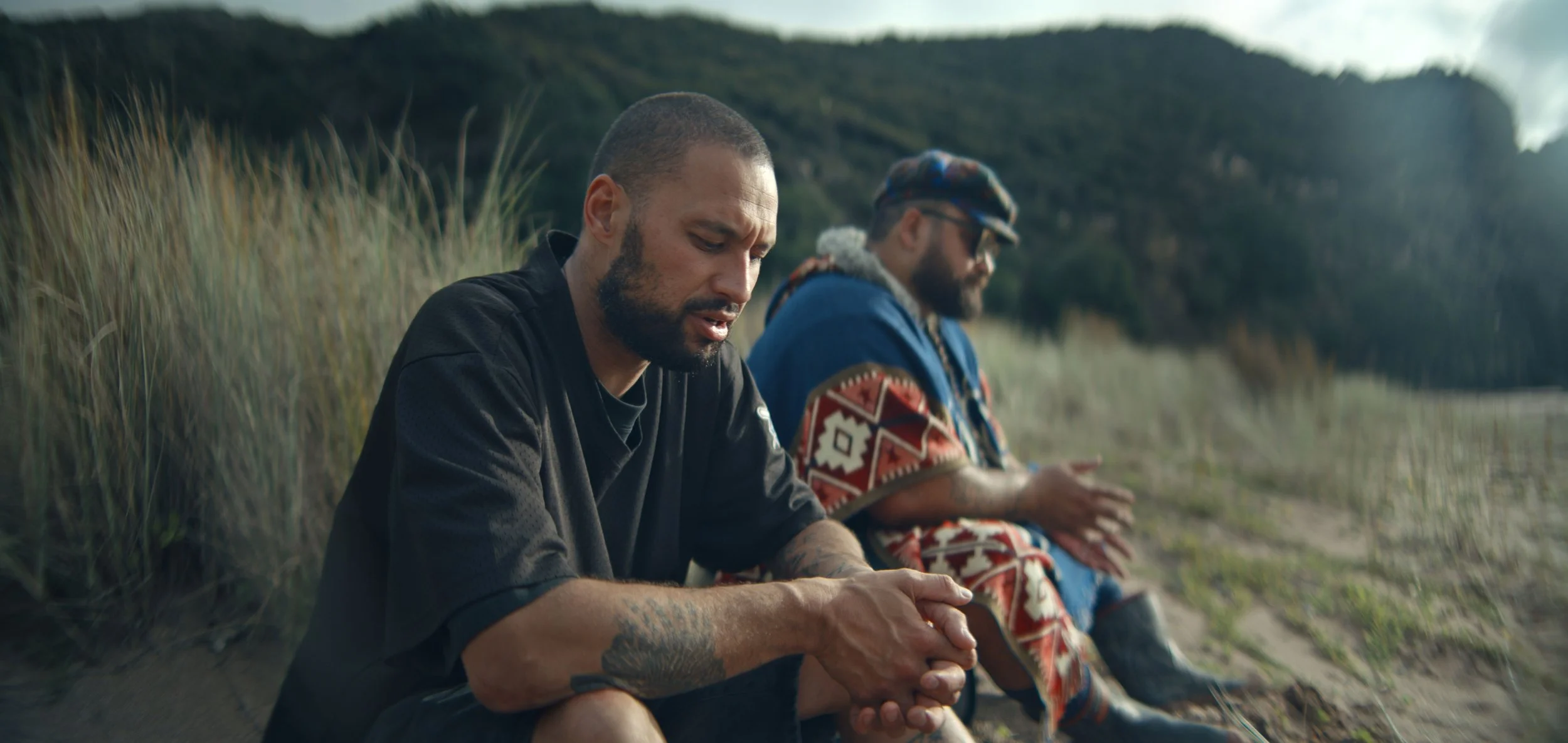 Nathan Taare and Troy Kingi sit on a beach discussing perfume for the series Journey of Scent on RNZ