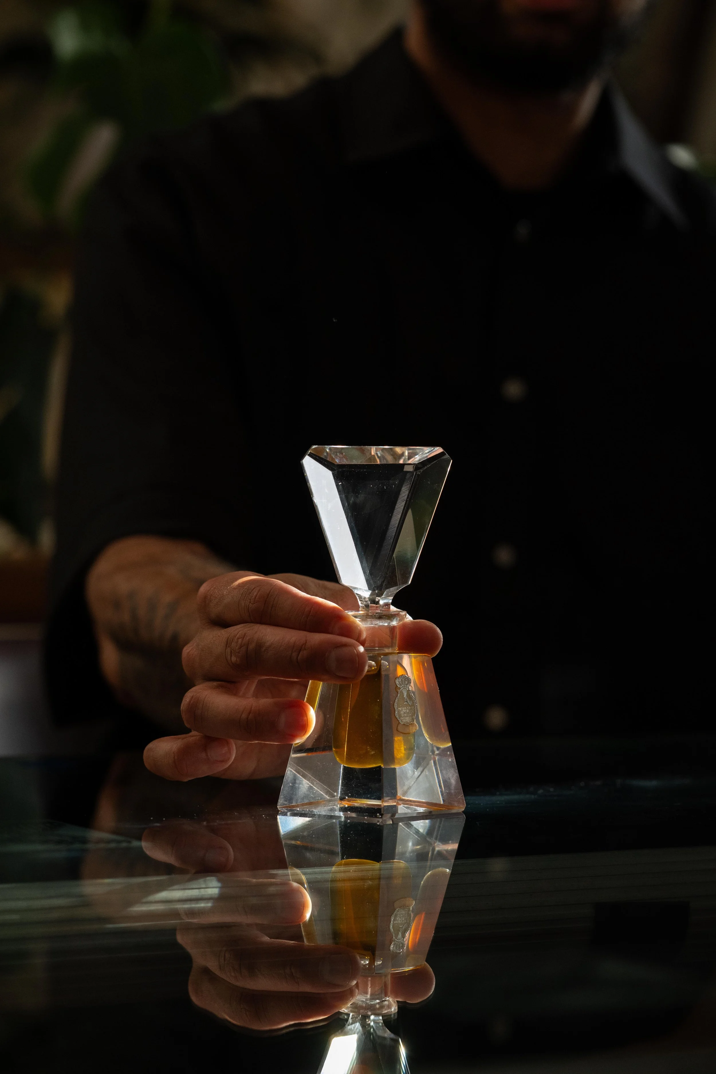 A vintage perfume bottle is presented by the hand of perfumer Nathan Taare