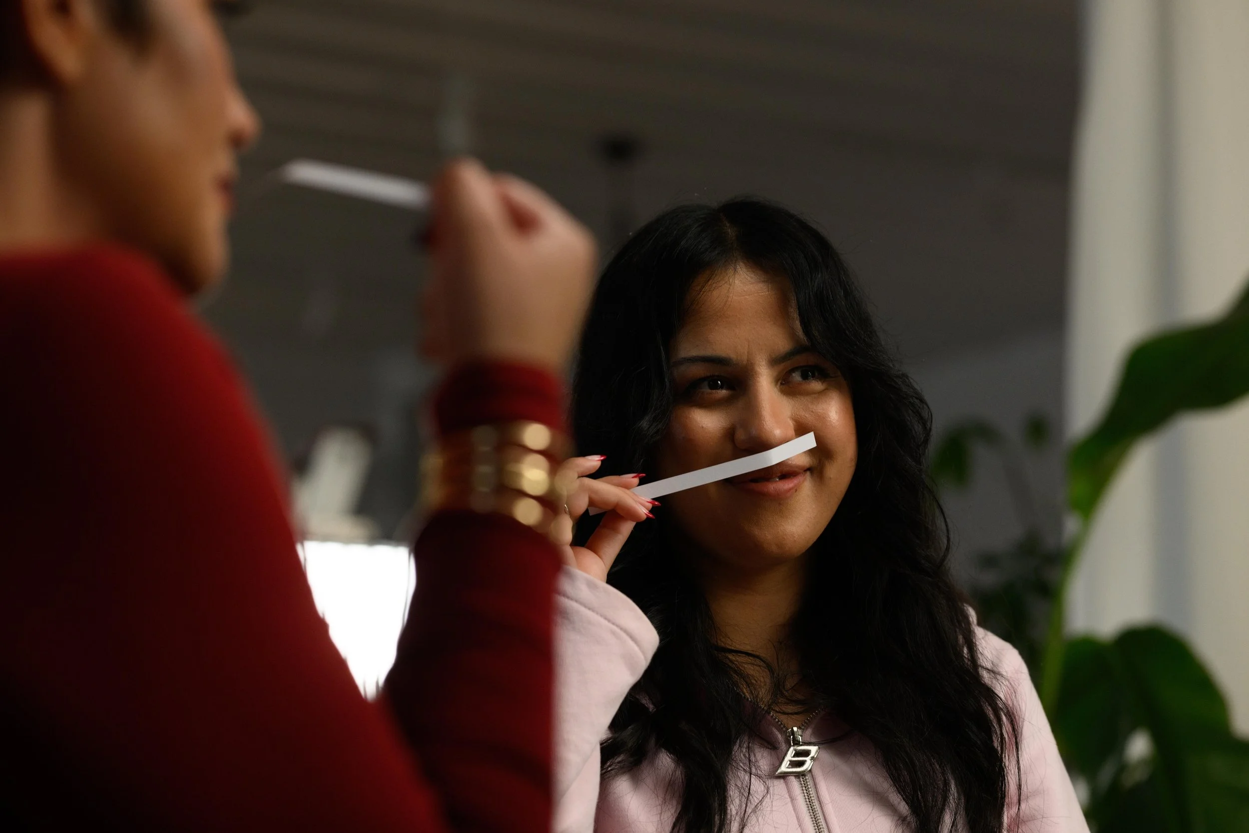 Poet and writer Tayi Tibble smells a scent stick. Whitney Steel is doing the same in the foreground.