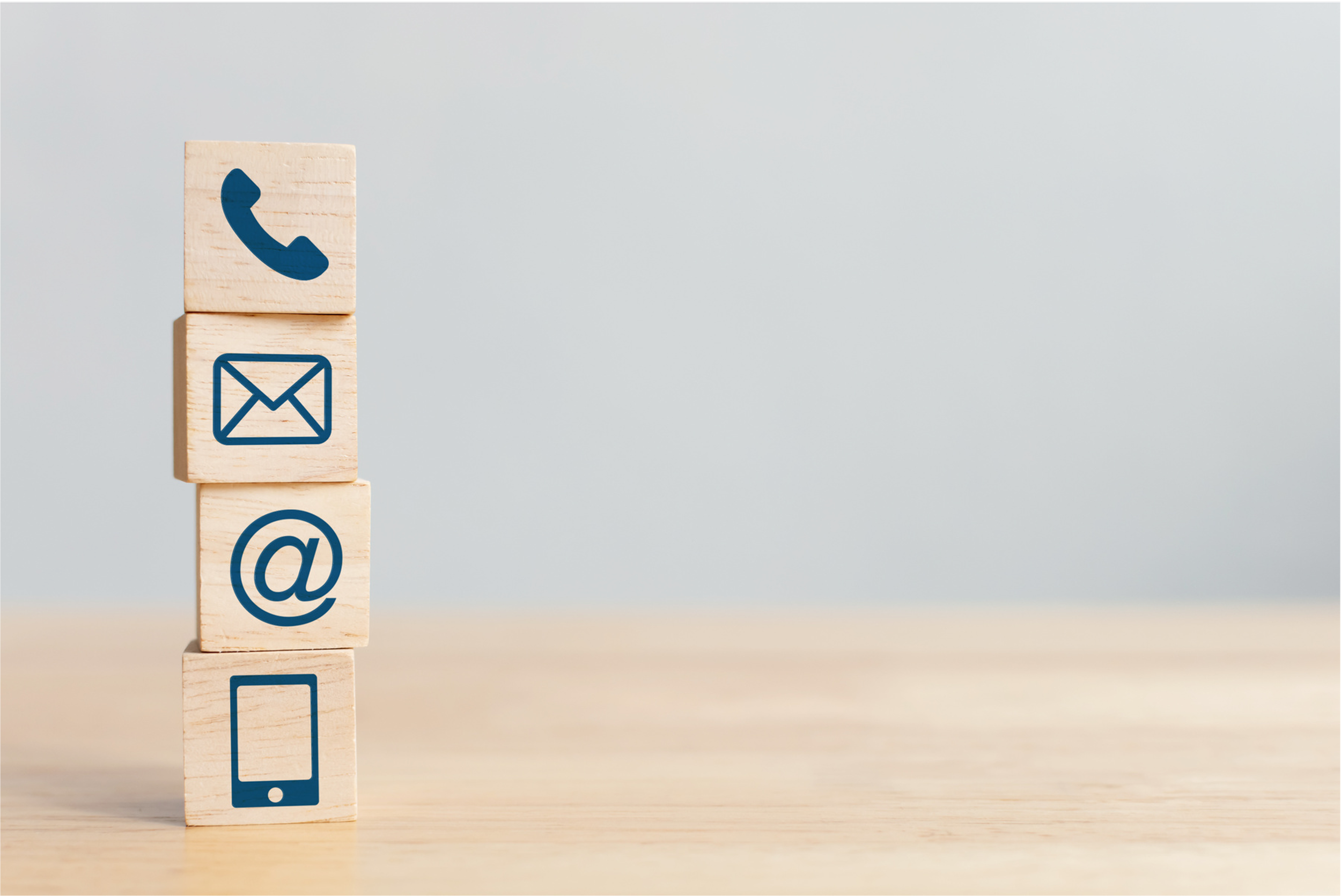 Stacked wooden blocks with phone, email, social media and mobile icons