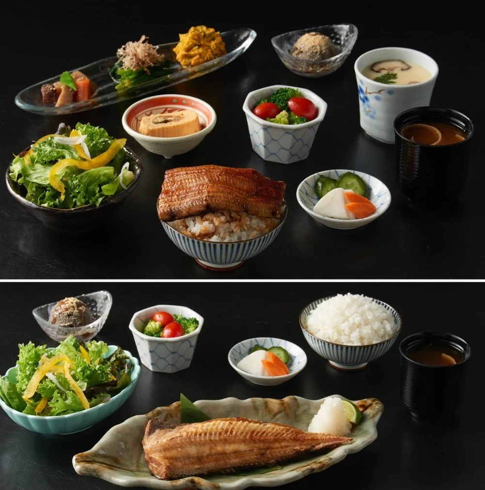 Two Japanese meals with rice, grilled fish, salads, vegetables, soup, and various side dishes arranged on black tables.