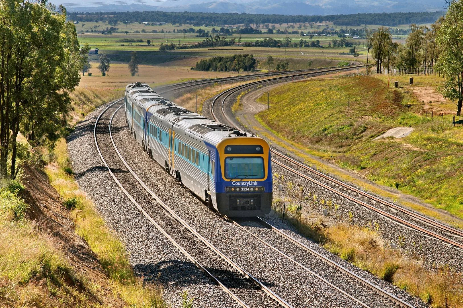 Passenger train travelling through rail infrastructure in regional NSW
