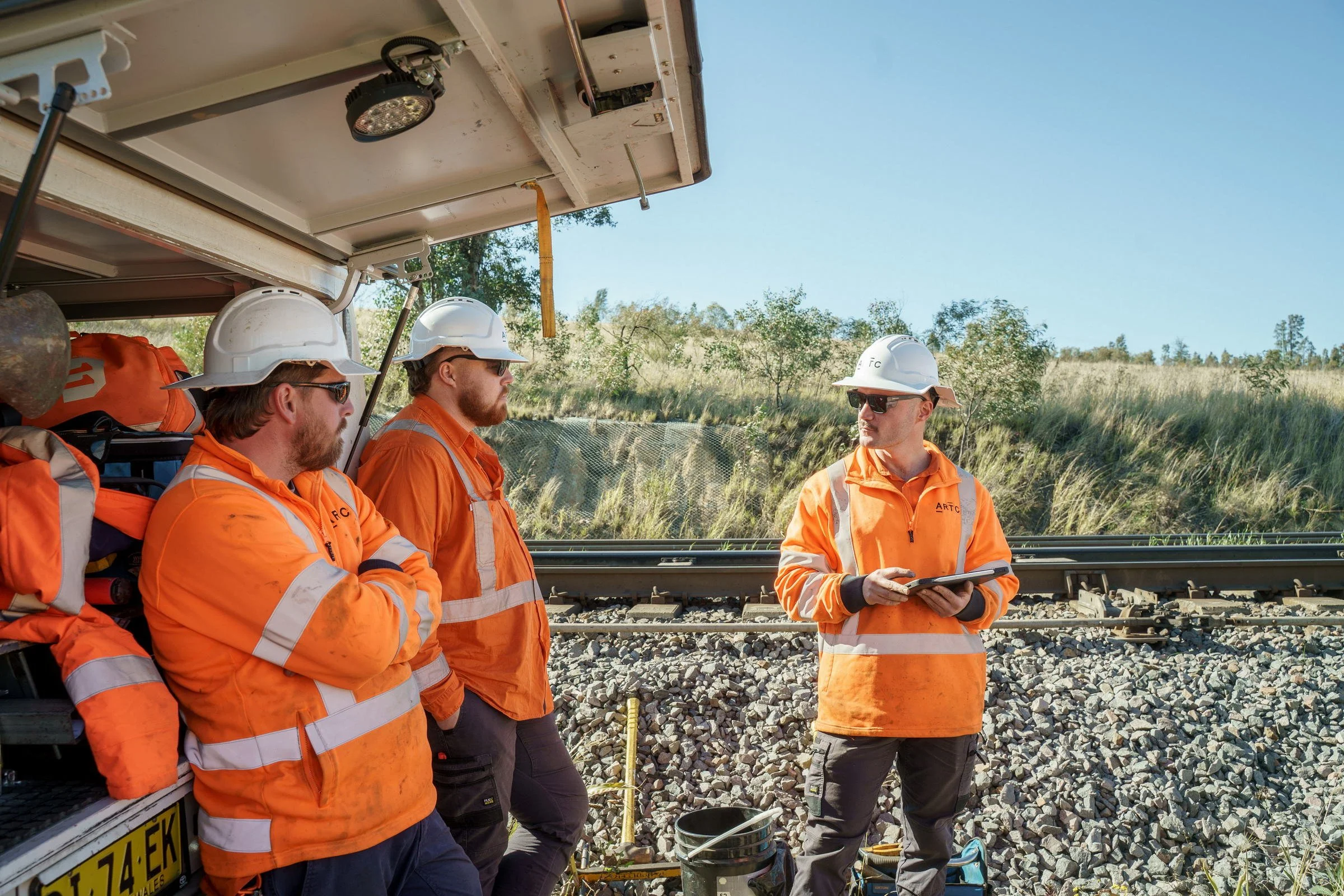 ARTC rail team photographed during a trackside briefing for rail infrastructure operations in NSW.