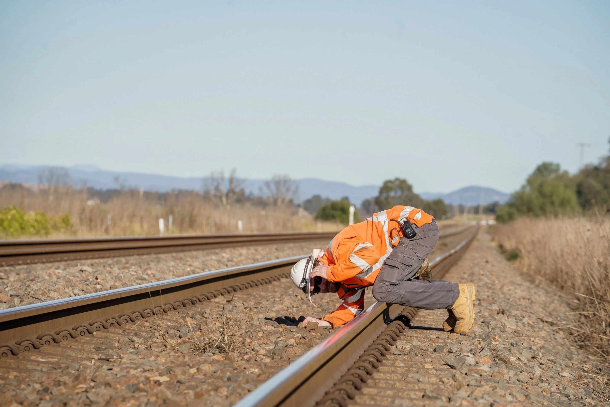 ARTC rail worker photographed inspecting track during rail infrastructure operations in NSW.