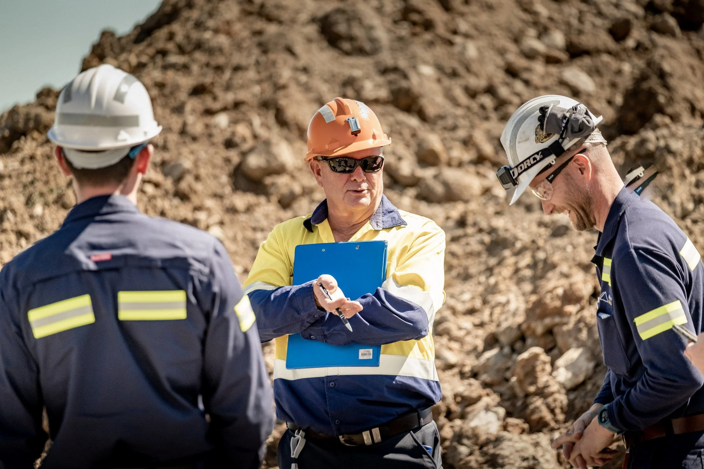 Mining inspectors and site personnel reviewing documents during an open-cut mine inspection in NSW.