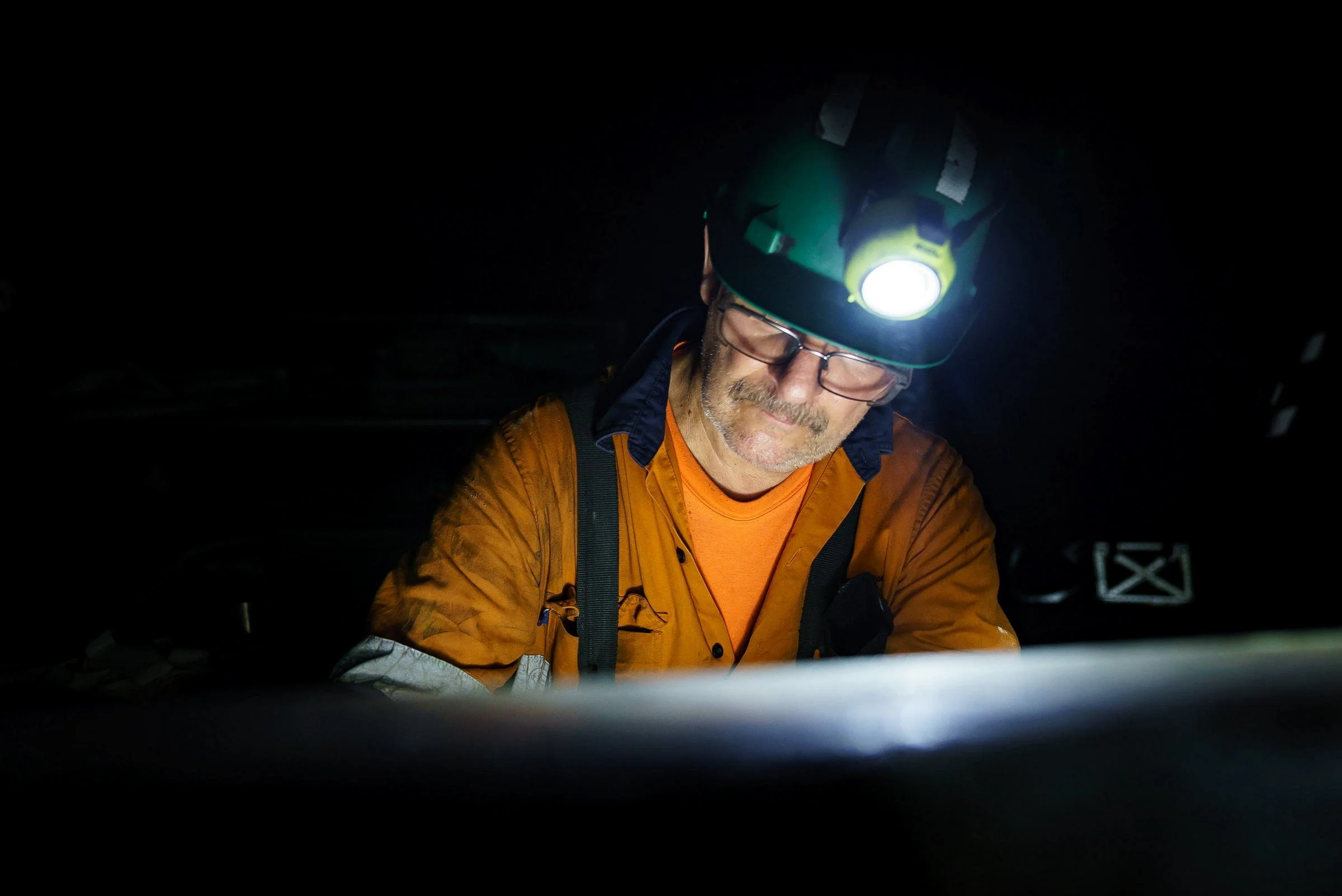 Underground mine worker with cap lamp photographed during a Myuna Mine operations shoot in NSW.