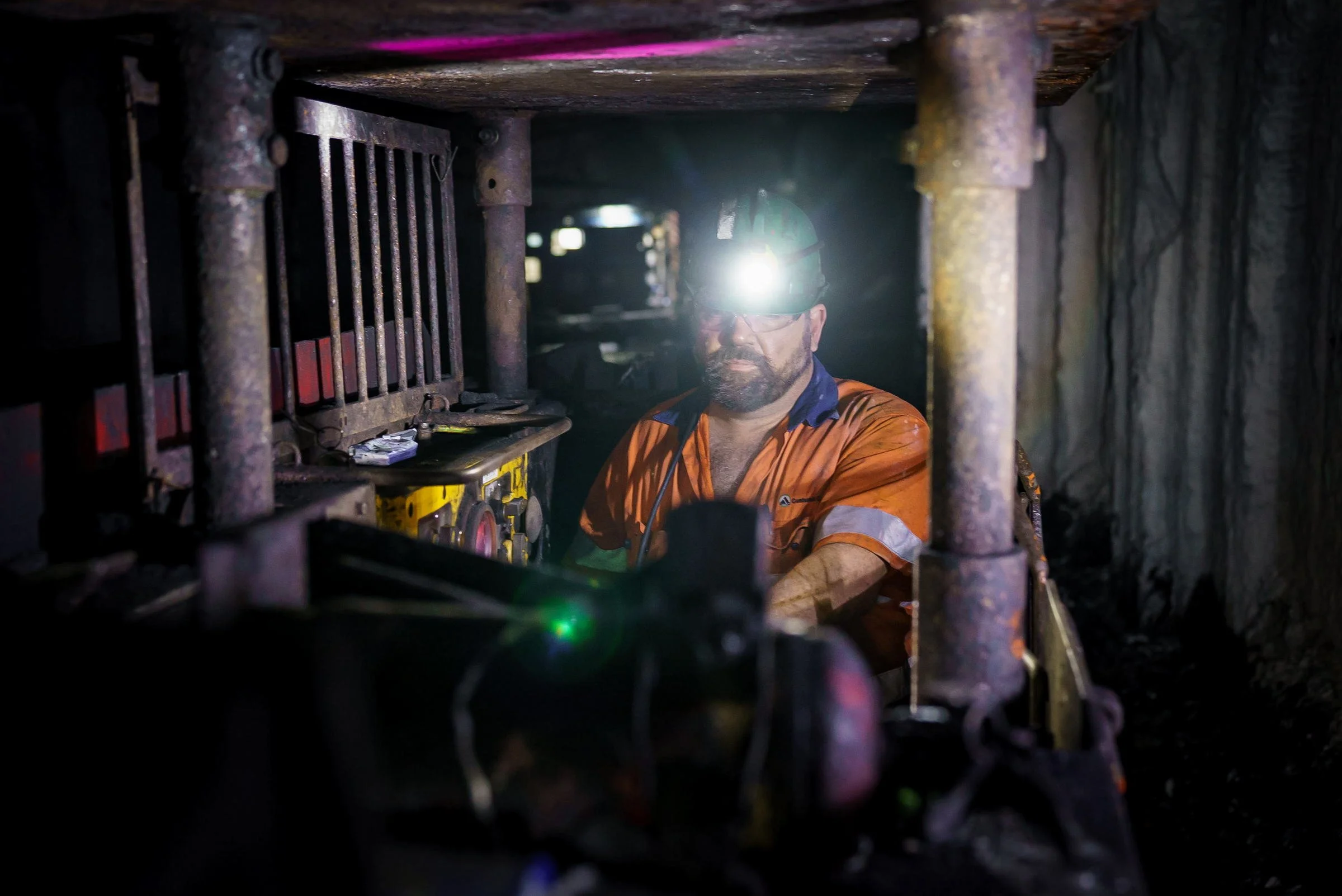 Underground mining equipment operating in a low-light roadway at Myuna Mine in NSW.