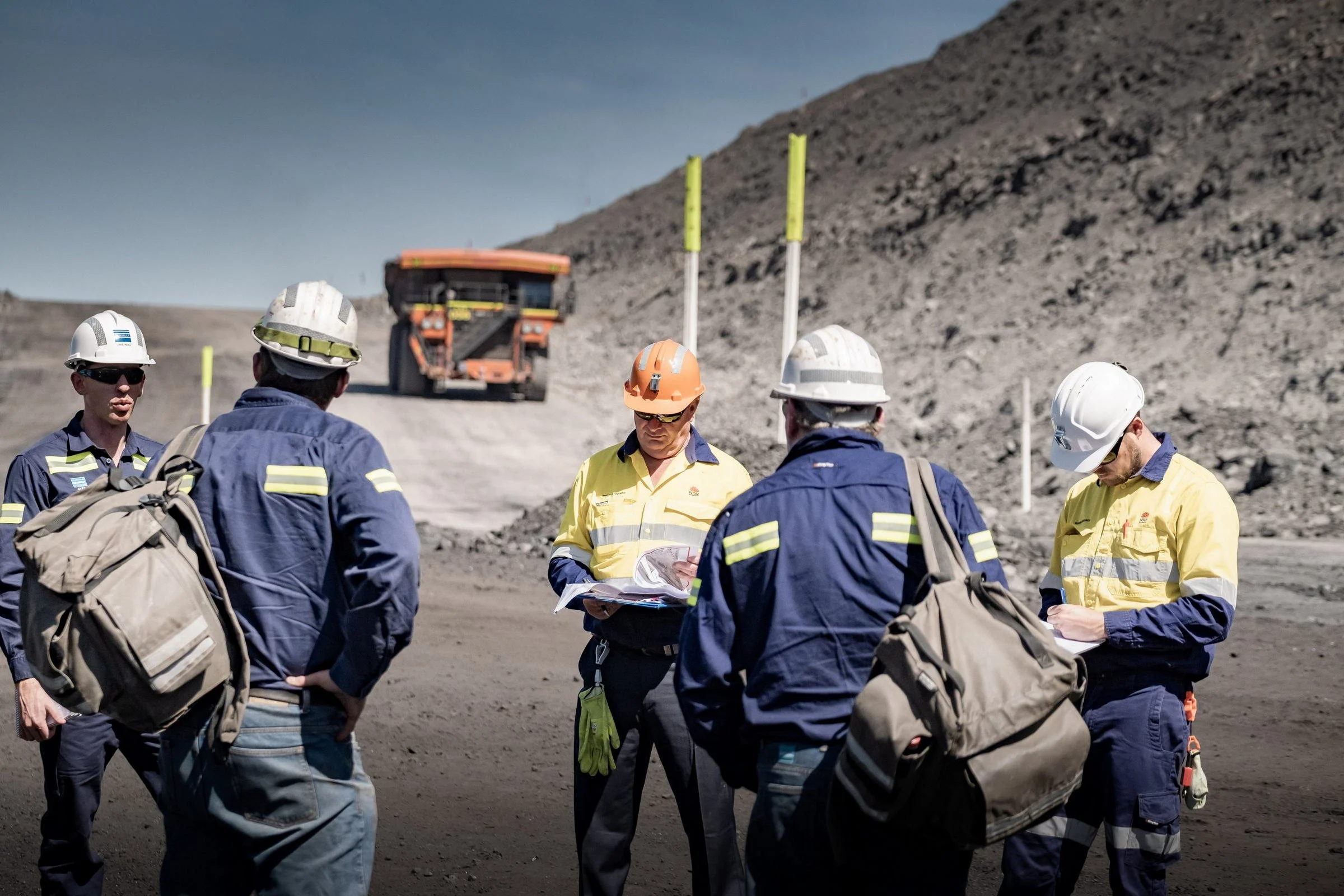 NSW Resources Regulator and site personnel standing in an open-cut mine pit during a site inspection.