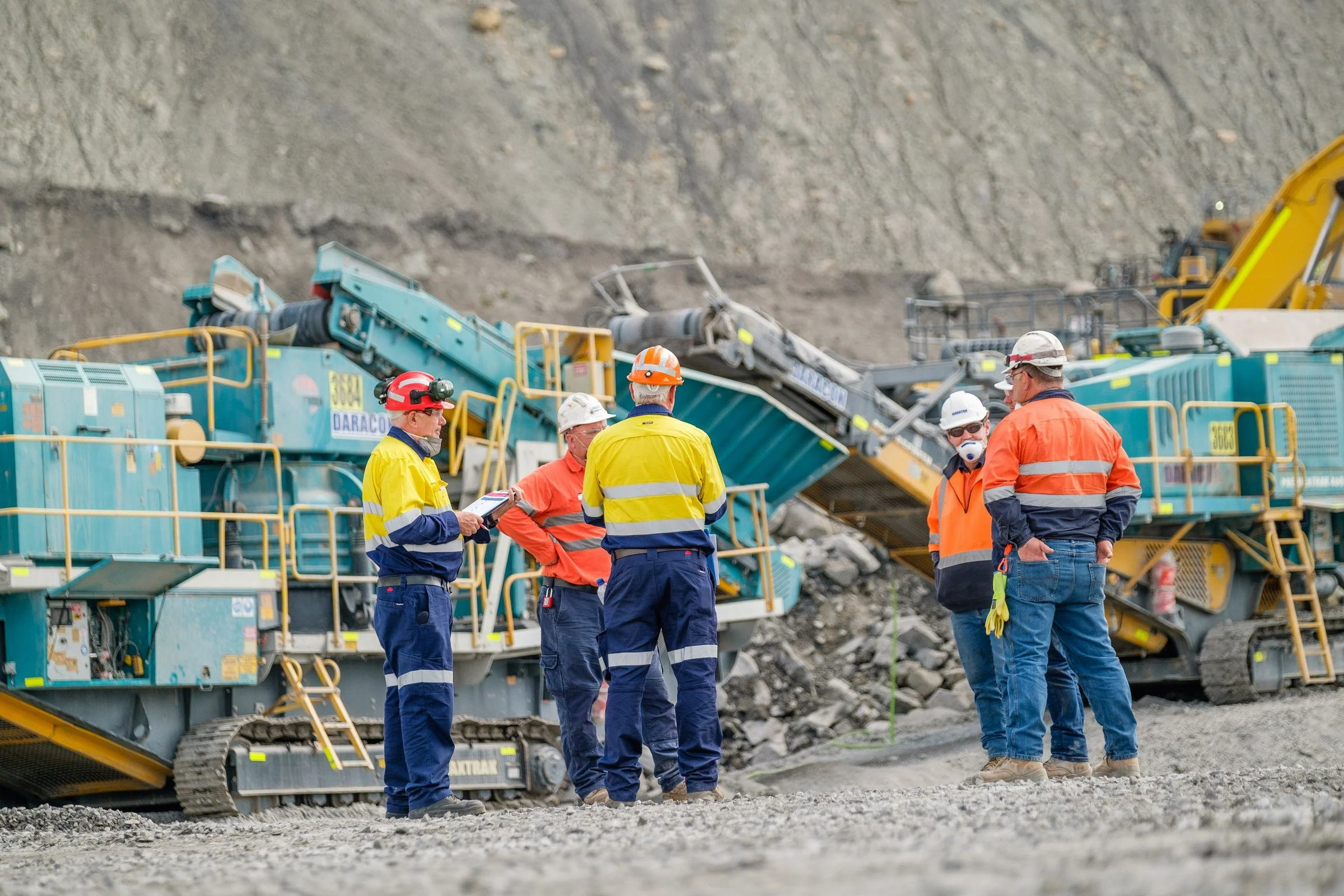 Mine workers and inspectors gathered around plant equipment during an open-cut mine site visit in NSW.