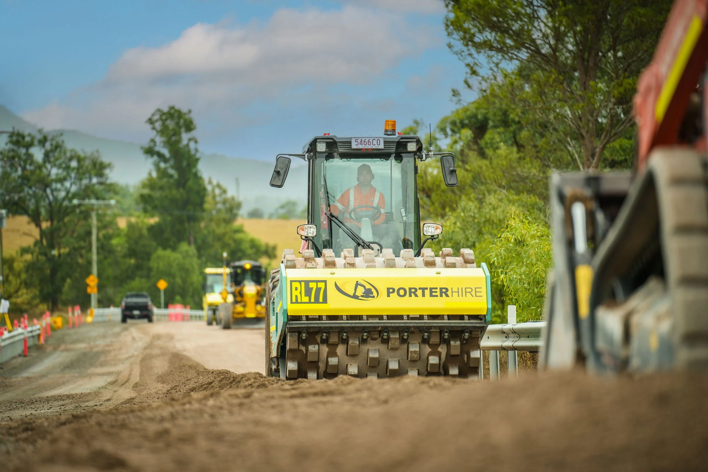 Porter Hire road roller operating with construction plant on site