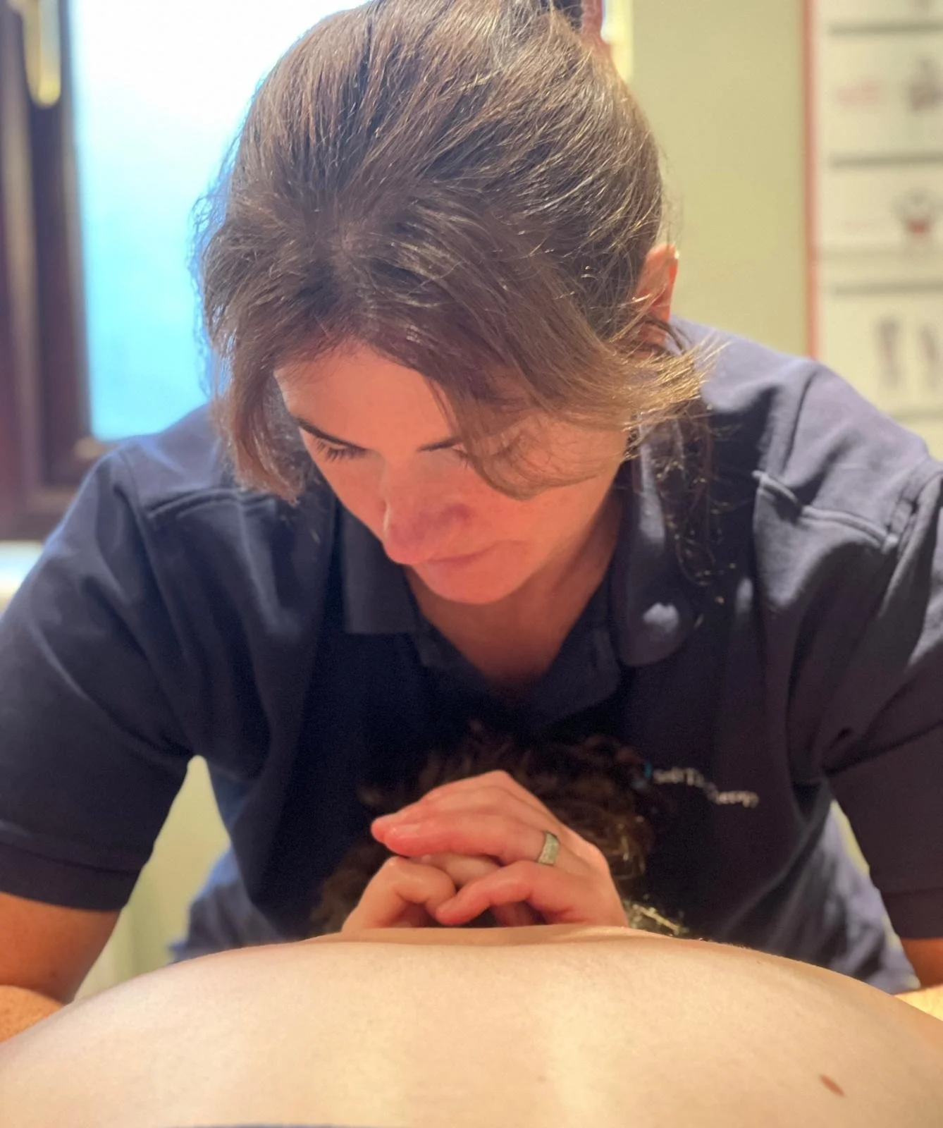A female providing a massage  to a client's back.