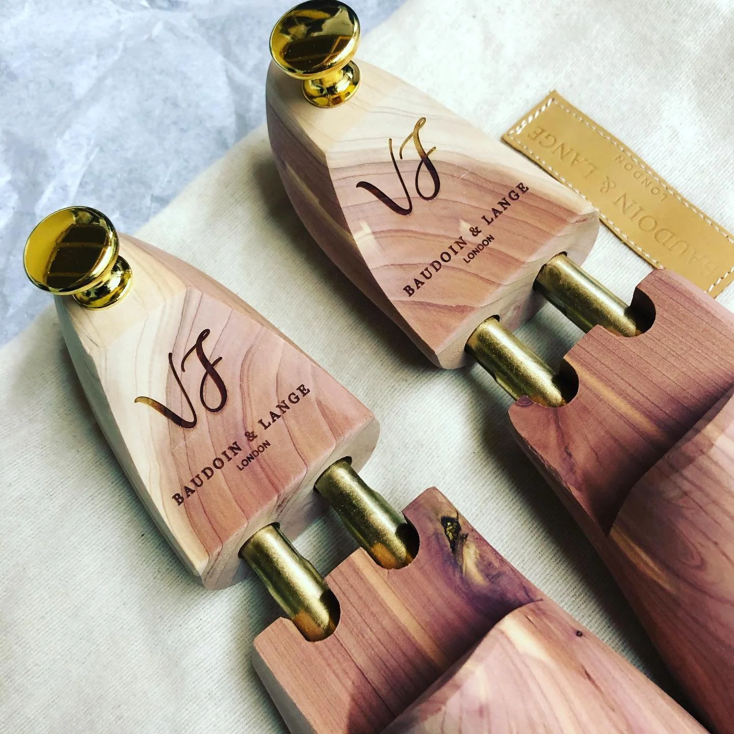 Close-up of two shoe trees with gold accents and the logo 'VJ' engraved.