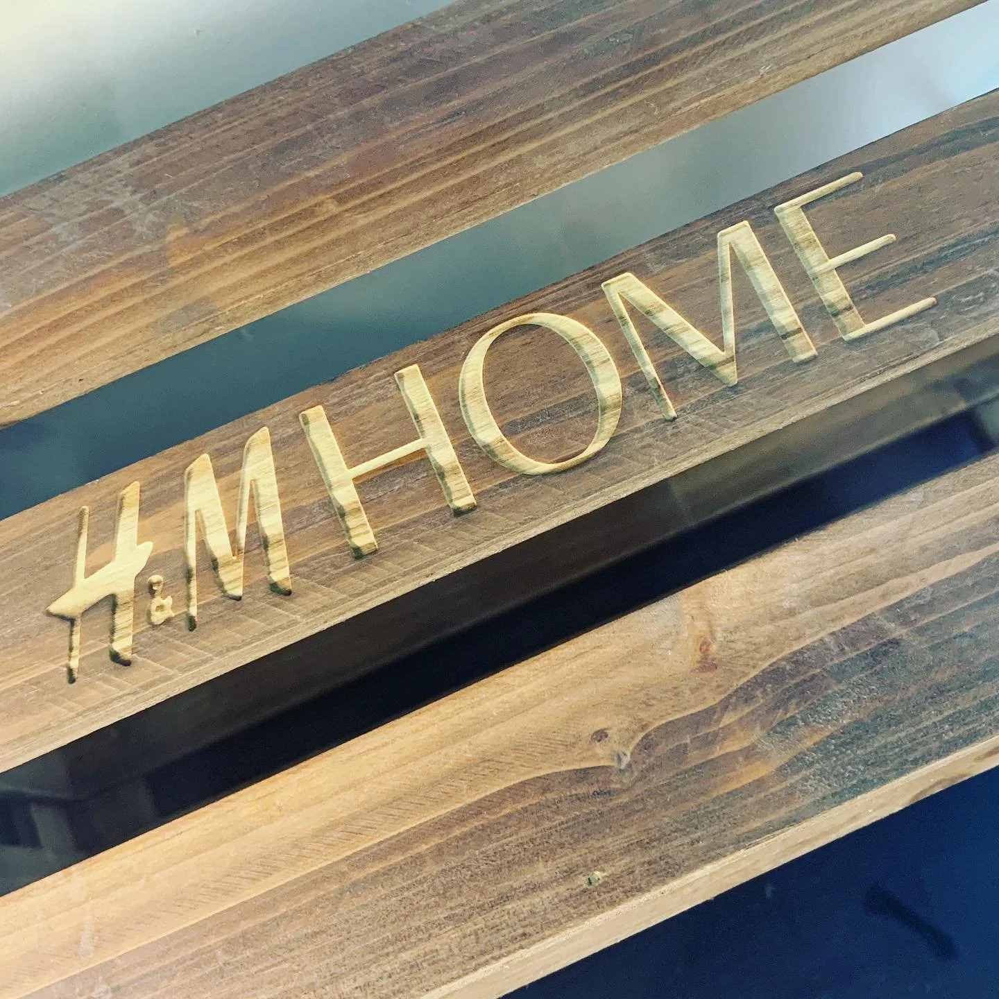 Close-up of a wooden box engraved with 'H&M HOME'.