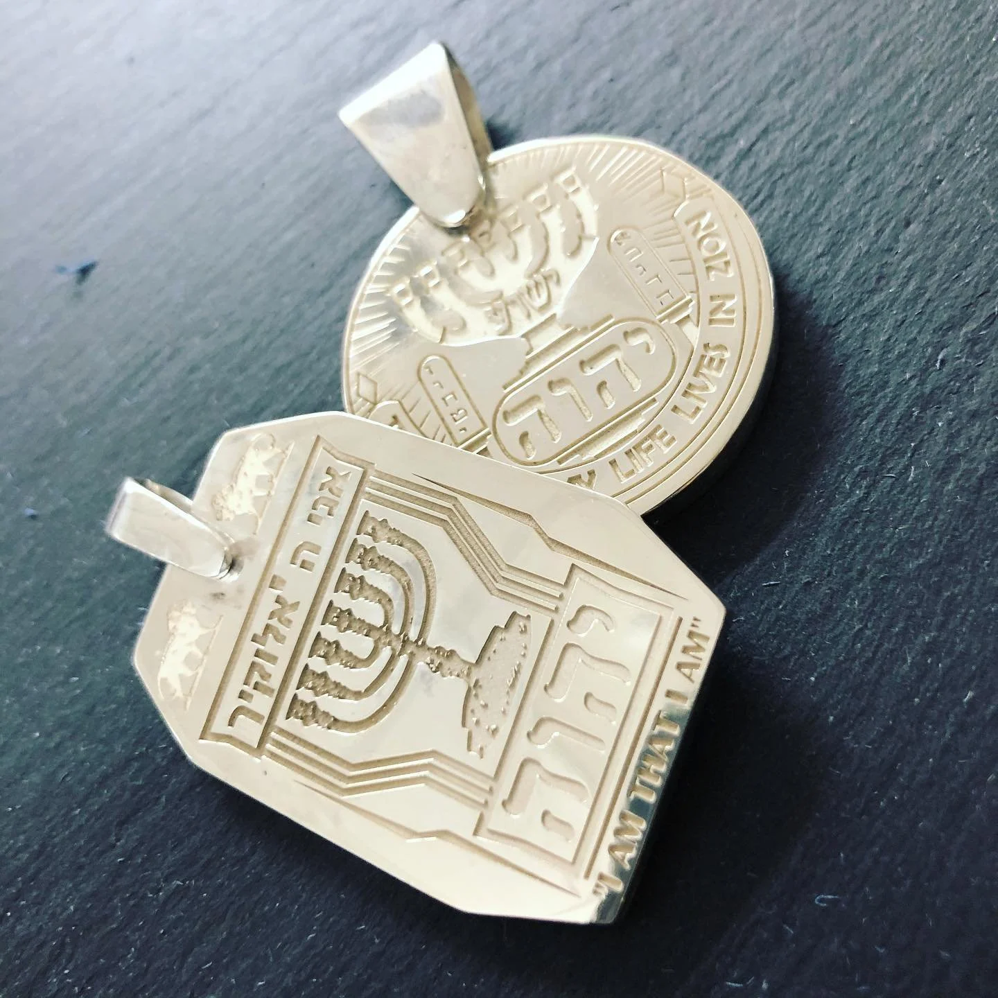 Silver pendants engraved with the Jewish menorah.