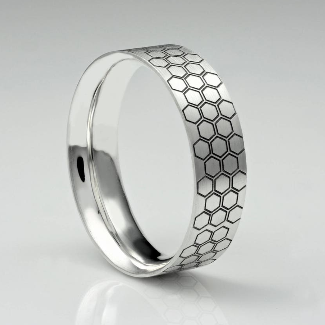 A silver ring engraved with a hexagon honeycomb pattern on the outside.