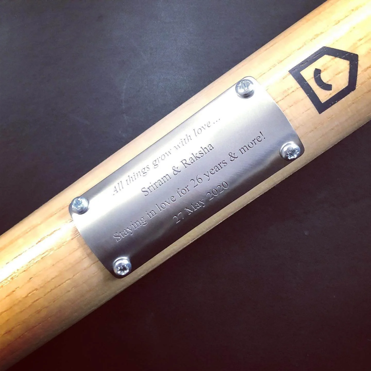 A garden spade with a metal plaque engraved with a message.