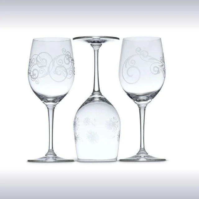 Two decorated wine glasses and one upside-down wine glass in the centre with an engraved snowflake designs