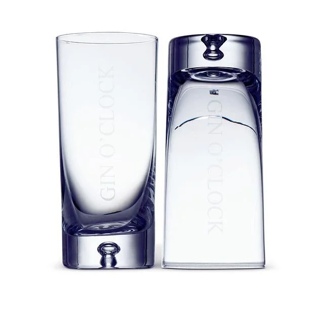 Two clear glass tumblers with a blue tint, one upright and one upside down, with the text 'GINO CLOCK' laser-engraved on both glasses.