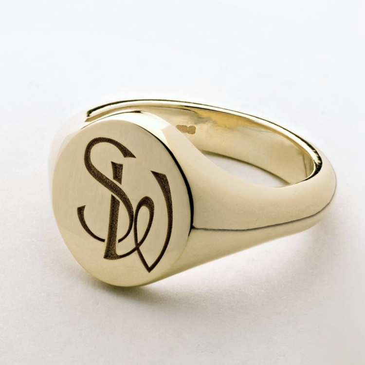 A Gold signet ring engraved with the initials 'SD' on a white background.