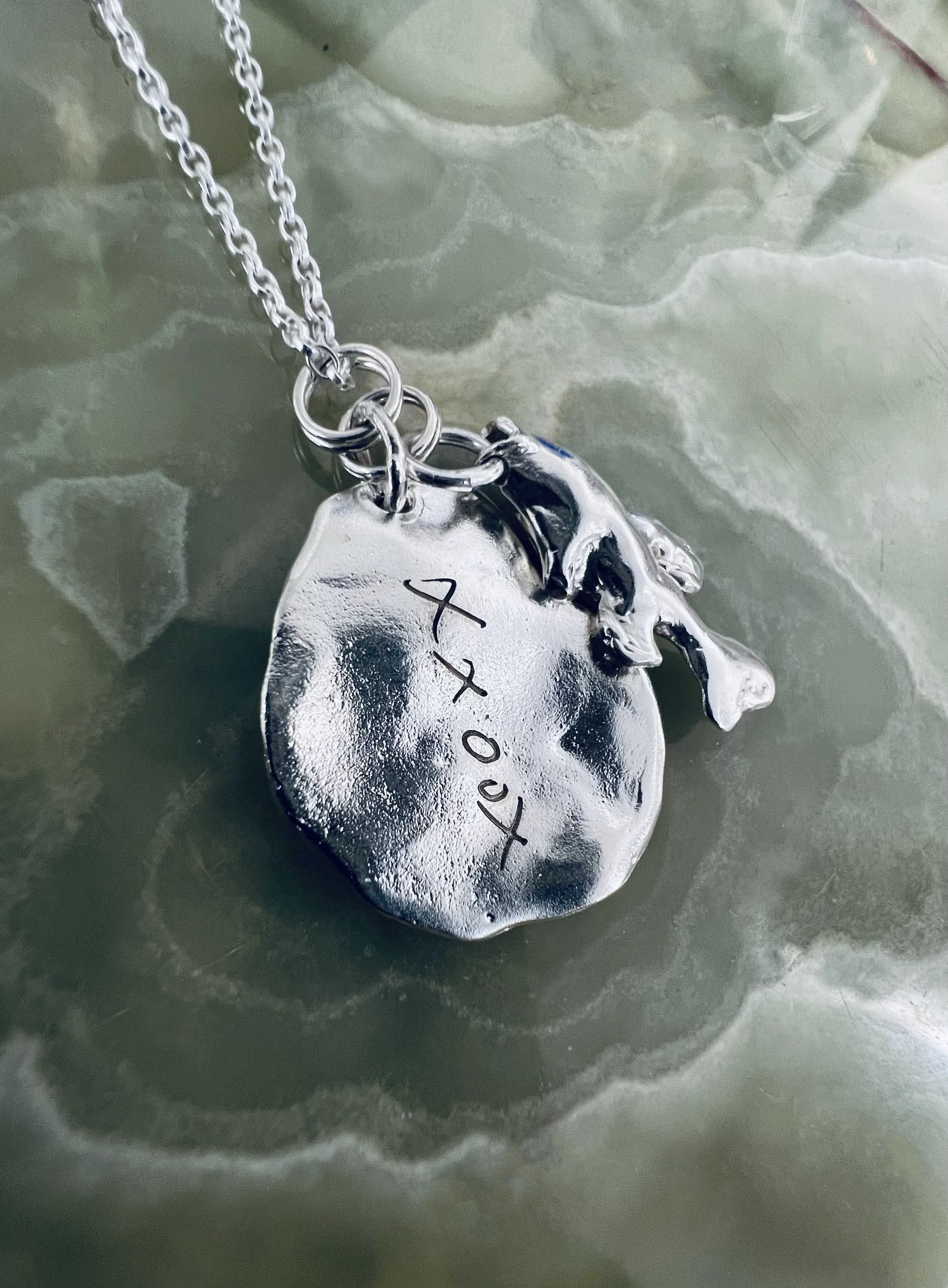 A customer brought in a hand-drawn 'XXOOX' sketch on a piece of paper. We scanned the artwork and converted it into a vector file, allowing us to laser-engrave the custom design onto their pendant necklace.