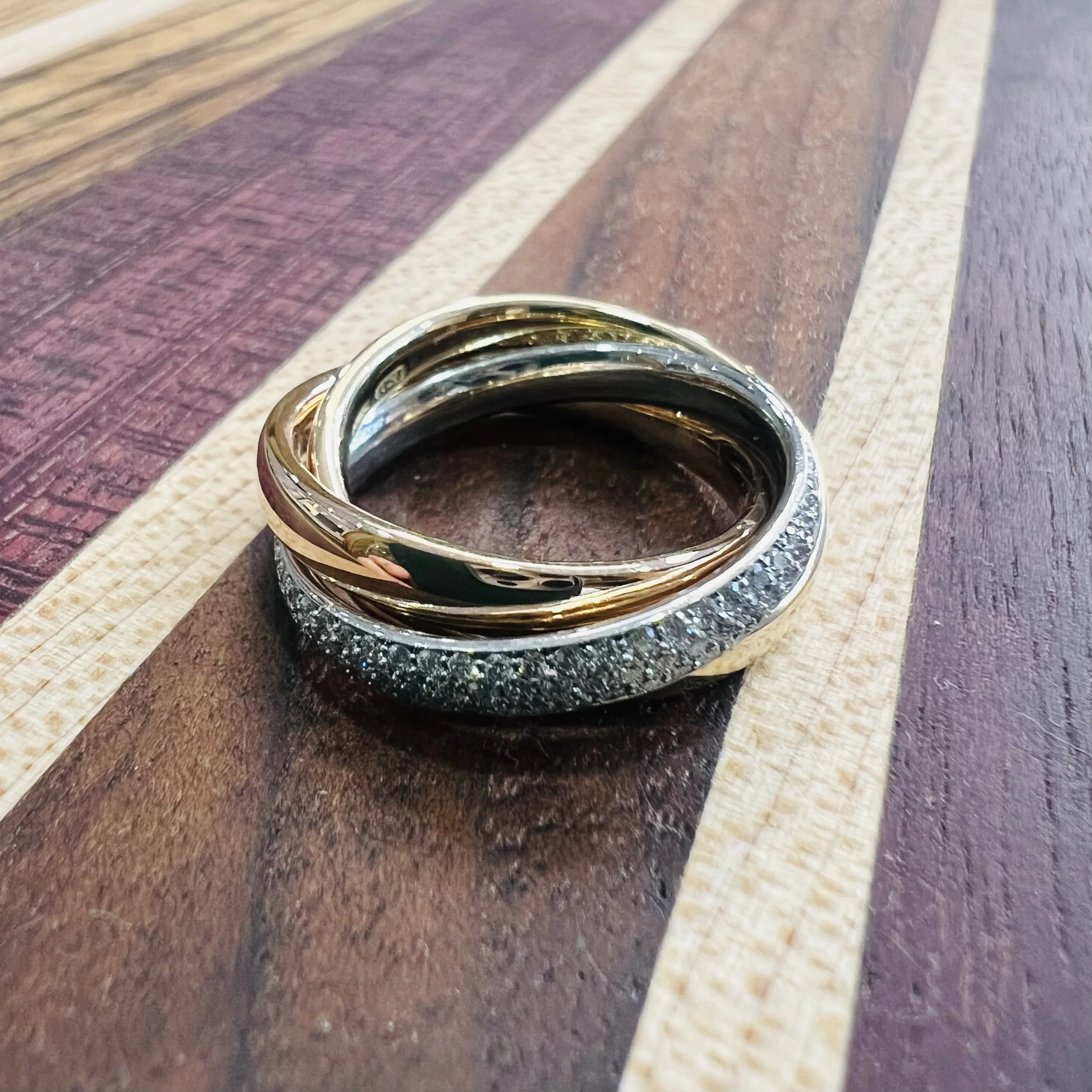 Contemporary take on the traditional Russian wedding band, handcrafted in the heart of Hatton Garden. This ring features three interlocking bands: rich 18ct yellow gold, platinum, and a showstopping white gold band pavé-set with brilliant-cut diamond