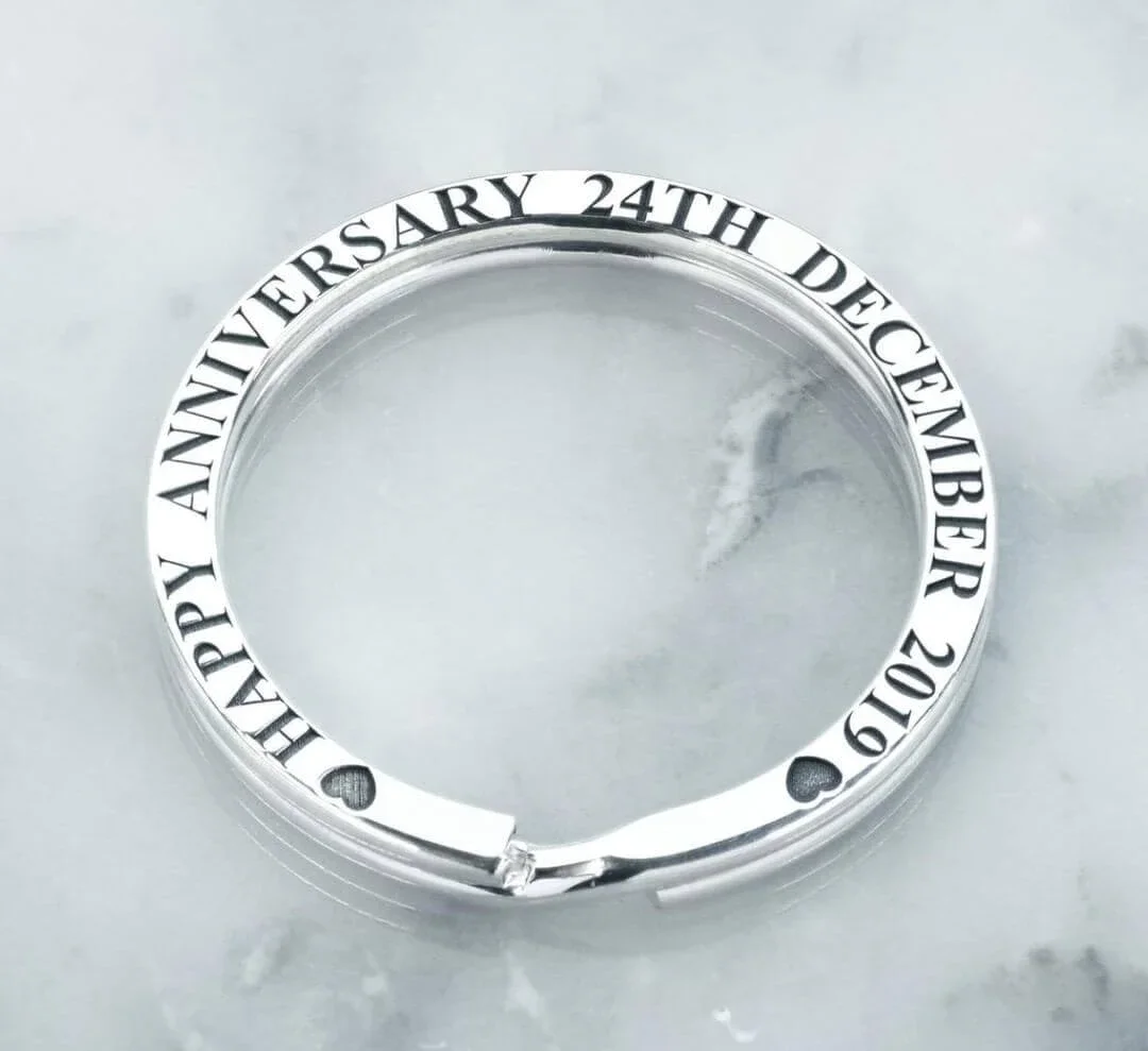 Silver key ring engraved with 'HAPPY ANNIVERSARY 24TH DECEMBER 2019' and small heart and spade symbols.
