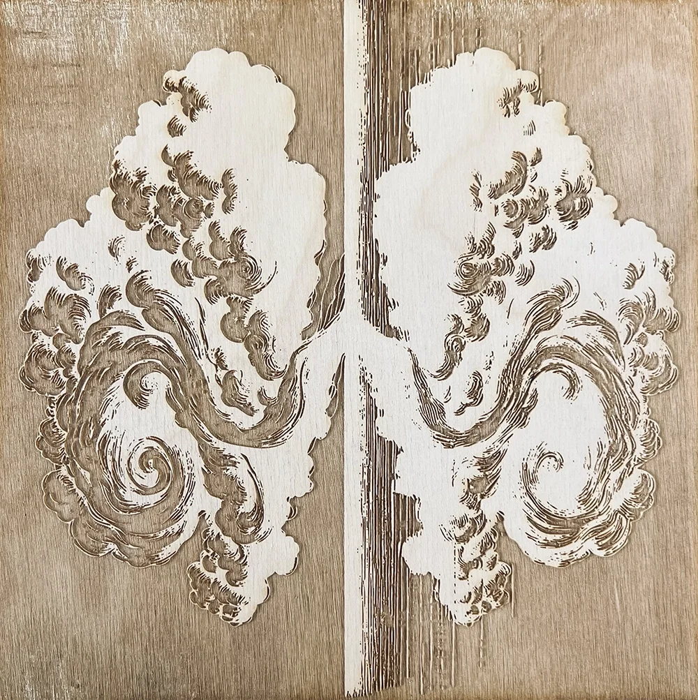 A decorative wooden panel engraved with an intricate design, split down the middle with a matching design on each side.