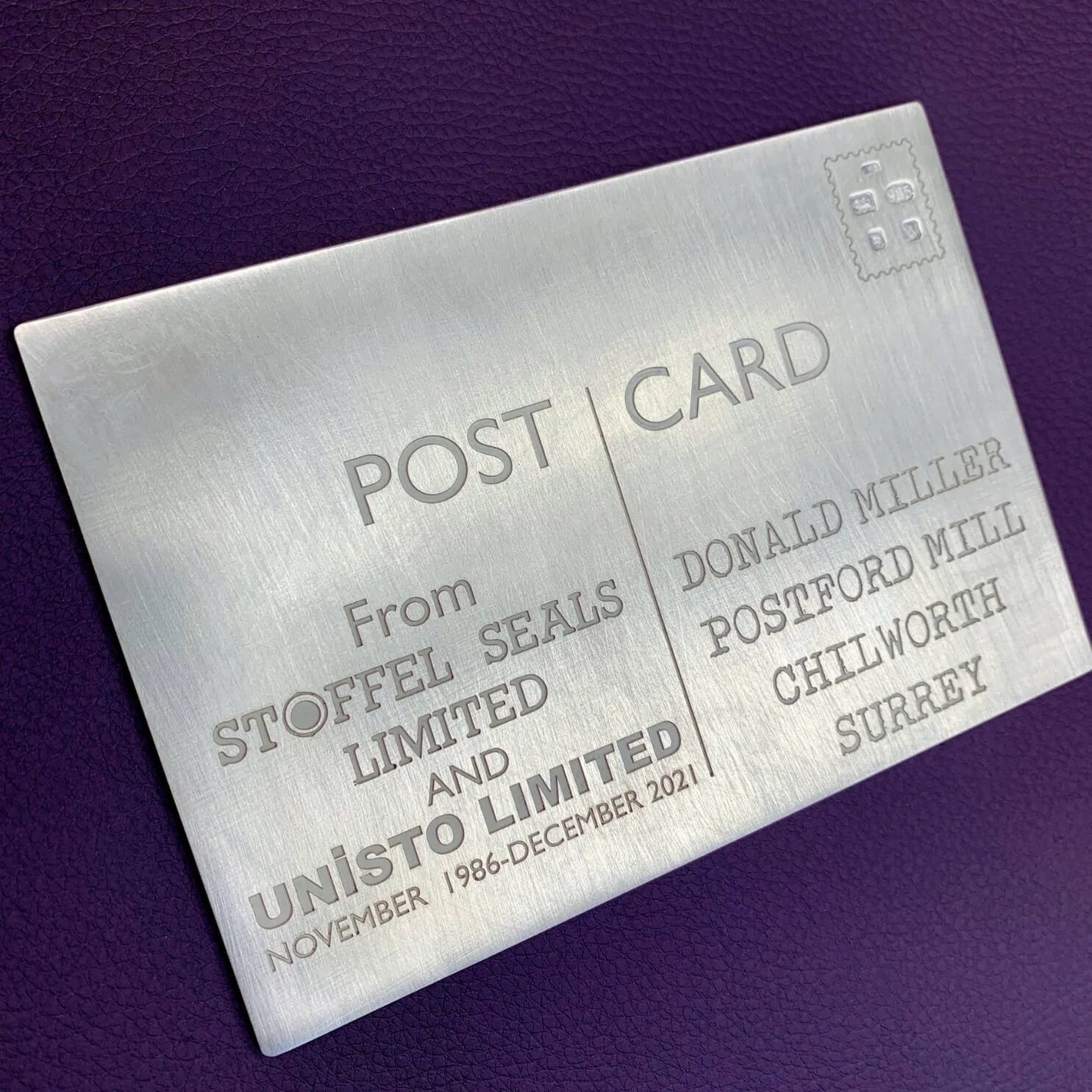 Metal plaque with engraved text indicating the sender, recipient, and date from 1986 to December 2021.
