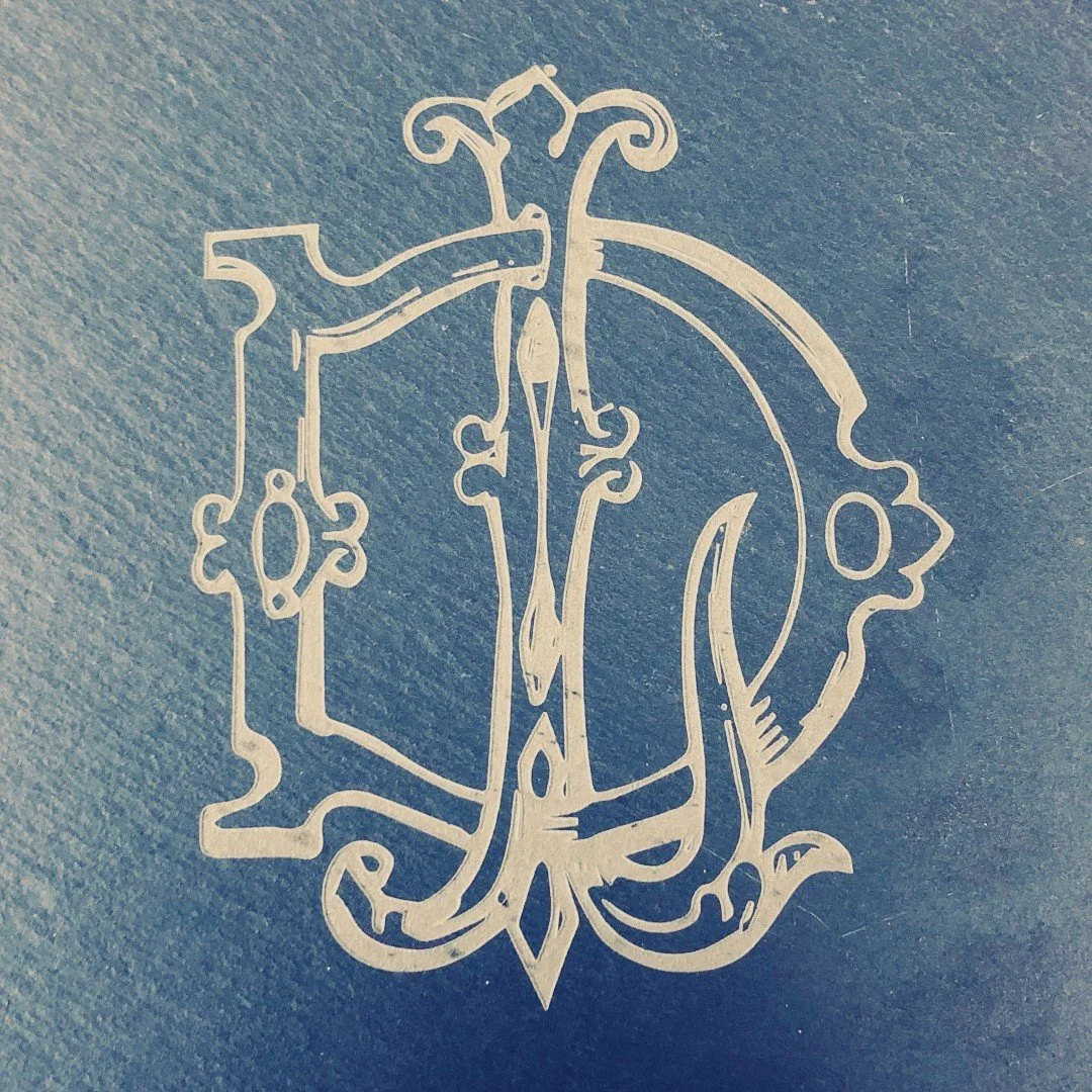 A slate plaque engraved with an elaborate monogram.