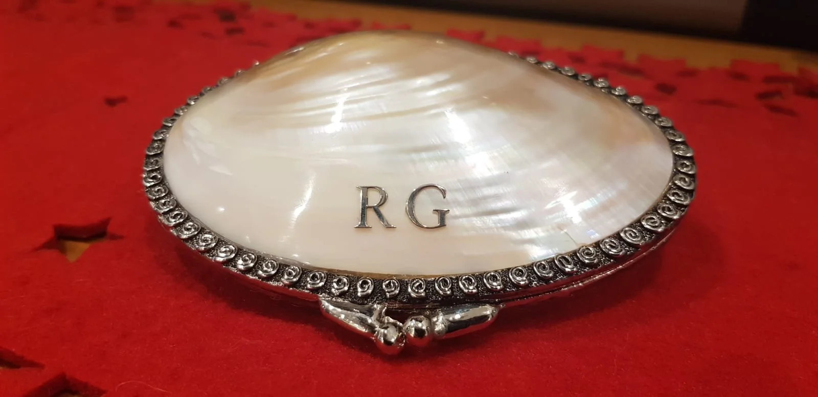 Example of two initials laser cut out of sterling silver and attached to a mother of pearl purse. 
