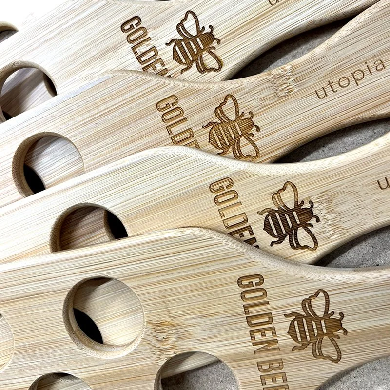 Several wooden spatulas with engraved bee and the word 'GOLDEN' on each.