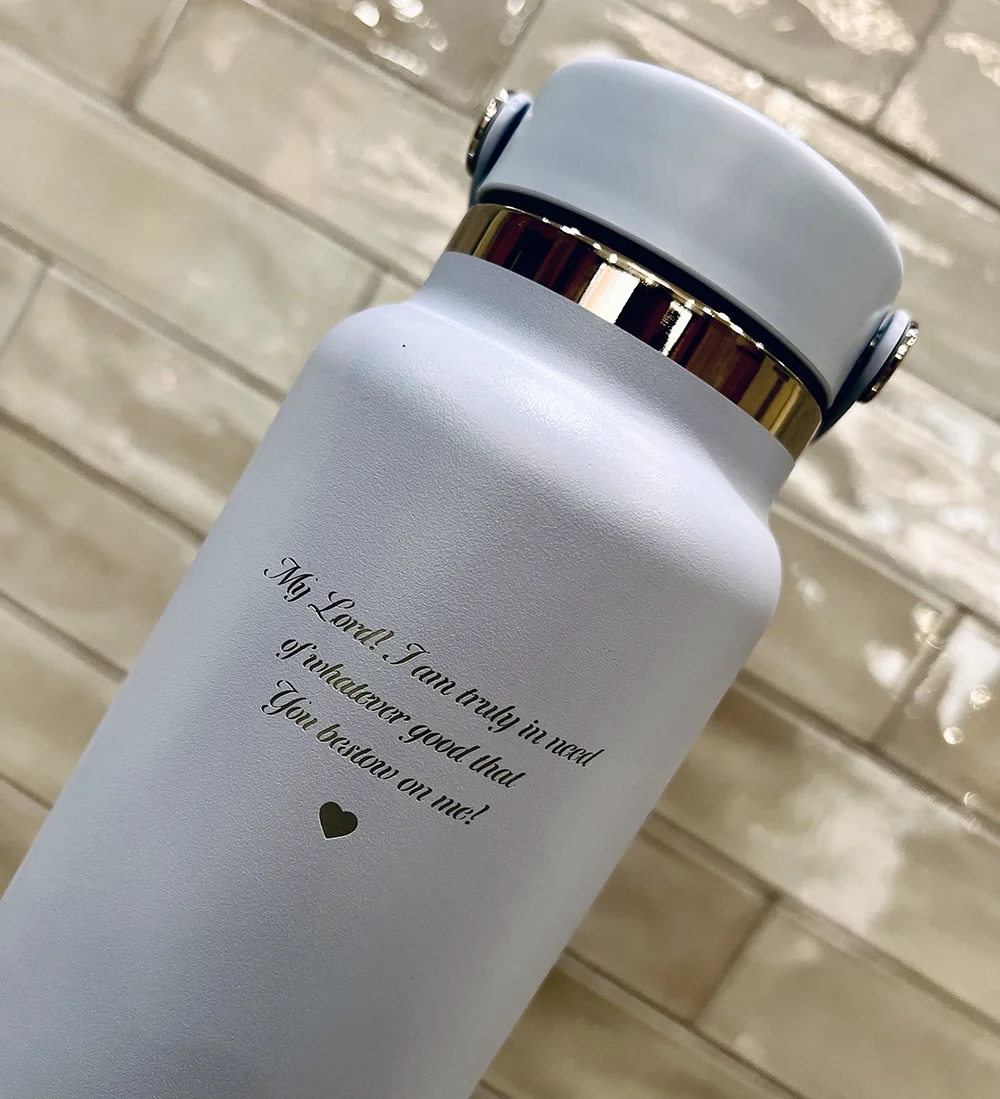 A drink flask engraved with 'My Lord, I am only in need of whatever good that You bring on me!' in black cursive font.